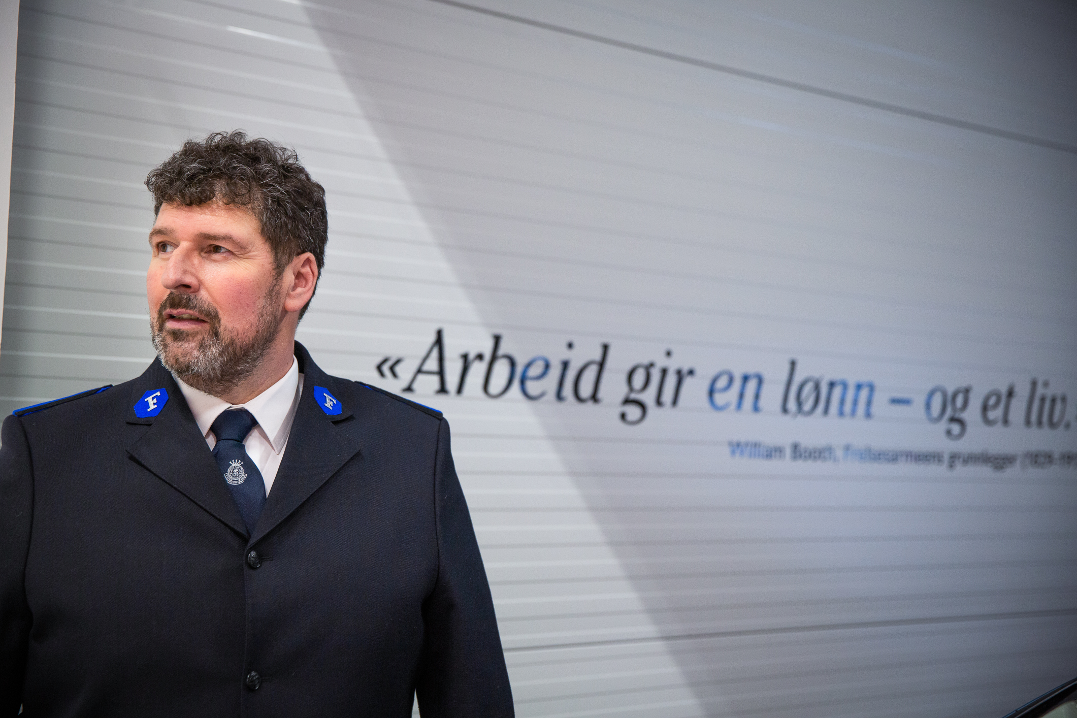 Poul i uniform foran sitatet til Willian Booth: –Arbeid gir en lønn – og et liv.