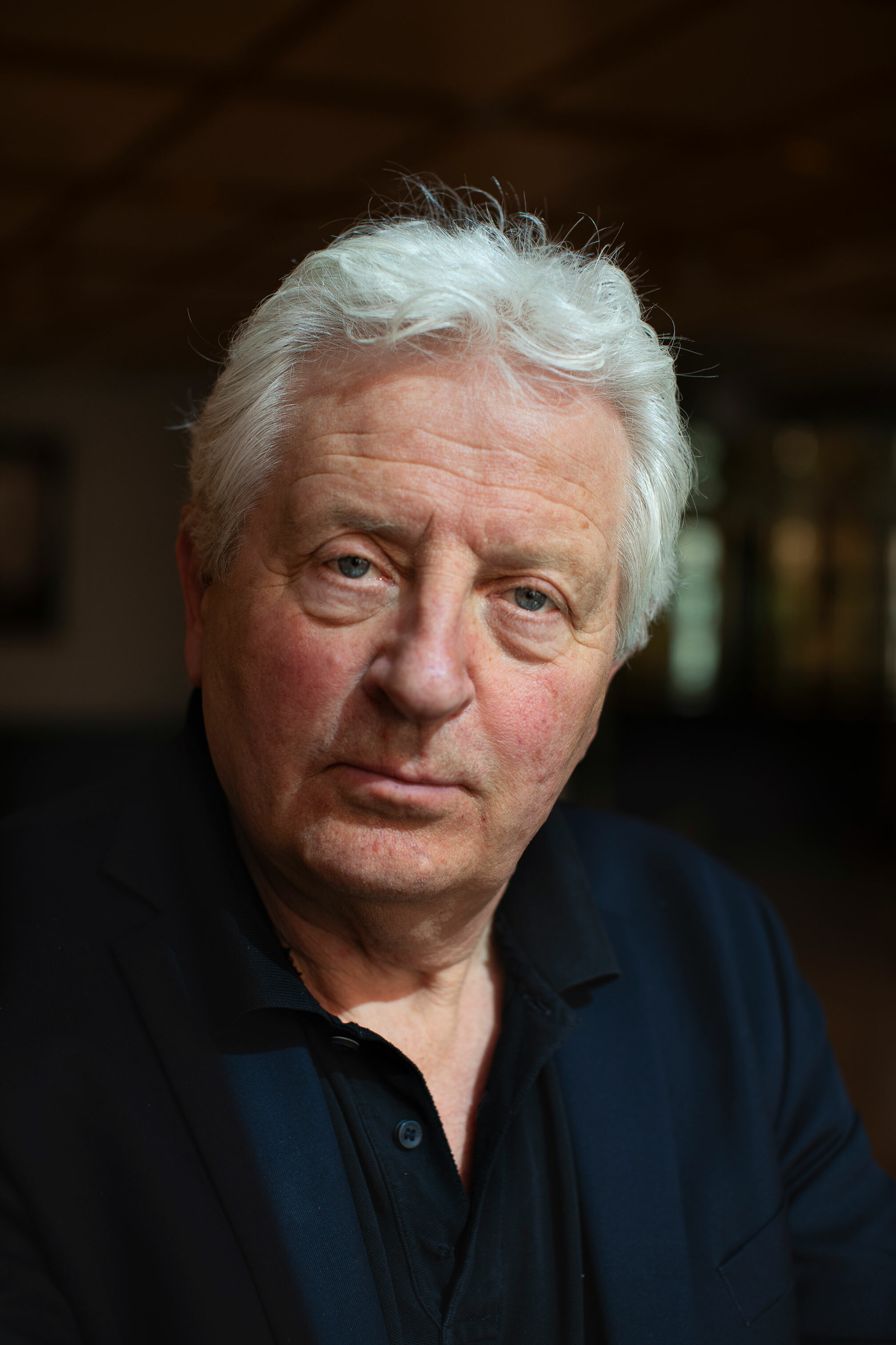 Foto: Nærbilde av en mann med grått hår. Han ser alvorlig ut.