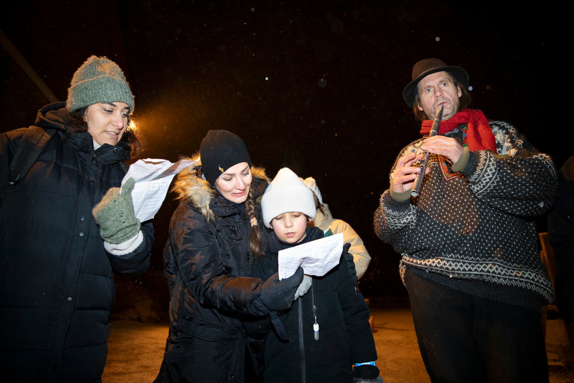 Foto: To kvinner, en gutt og en mann står på rekke. Kvinnene holder ark som det synges fra.