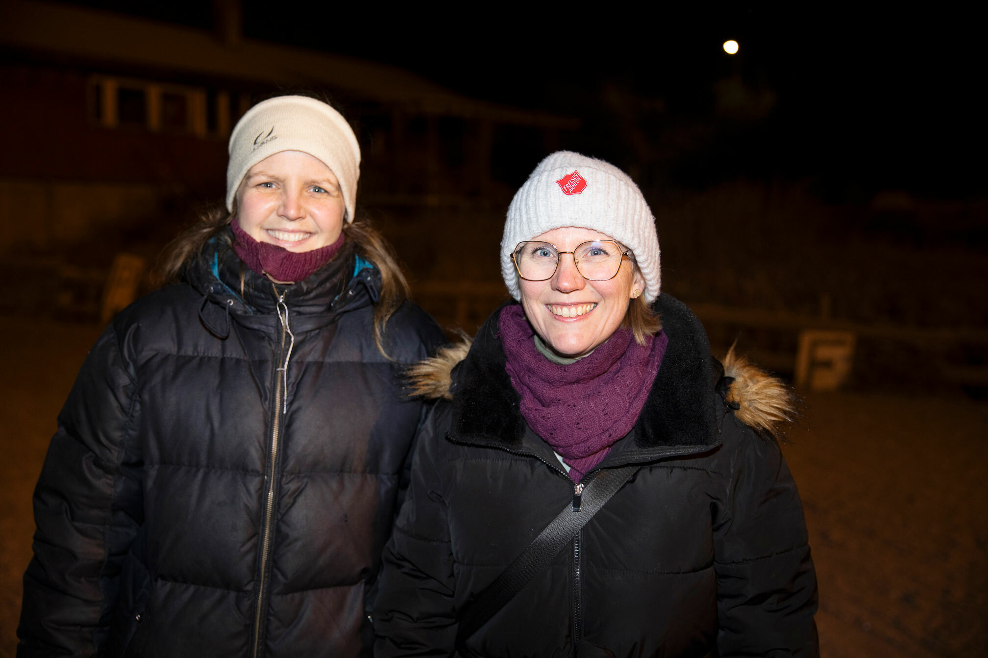 Foto: To kvinner i 40-årene med varme klær smiler til fotografen. Hun ene har briller og begge har litt røde neser.