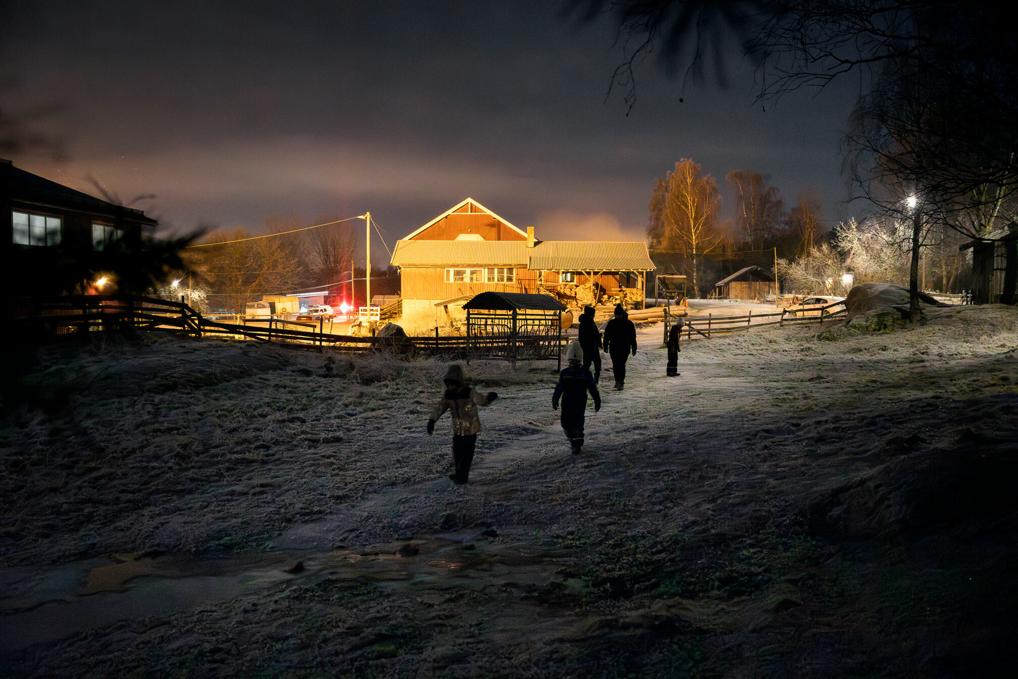 Foto: Fem-seks unger som leker på et gårdstun i mørket.