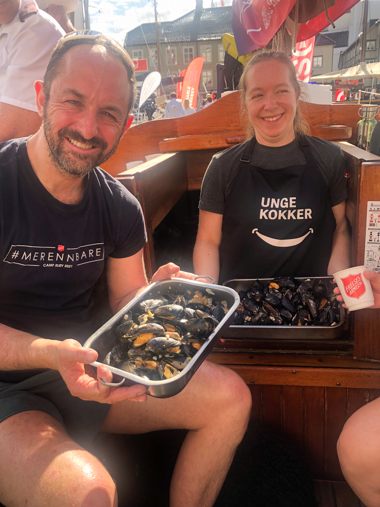 Mann og kvinne holder hvert sitt brett med blåskjell.