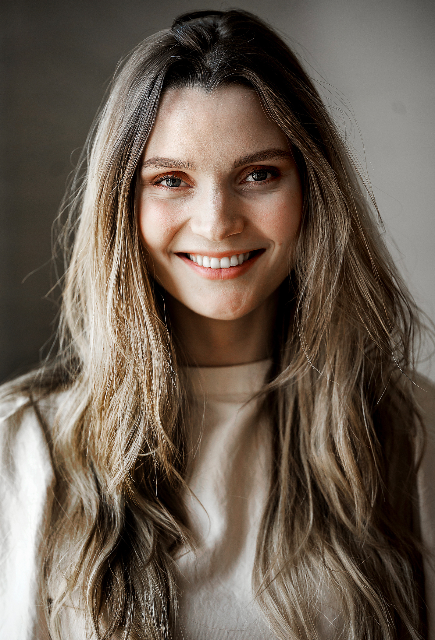 Foto: Nærbilde av ung kvinne med langt, mørkt hår. Vakkert smil i kamera.