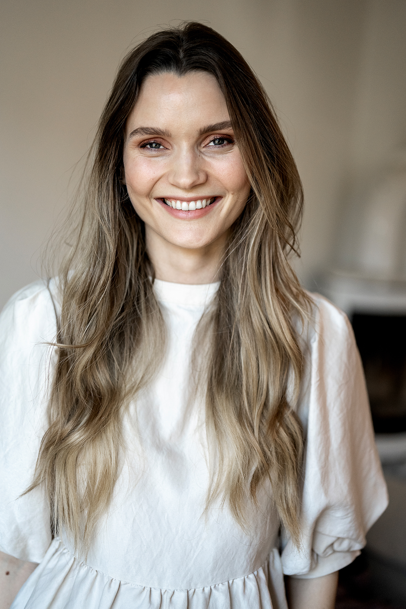 Foto: Kvinne med langt, mørkt hår smiler til kamera.