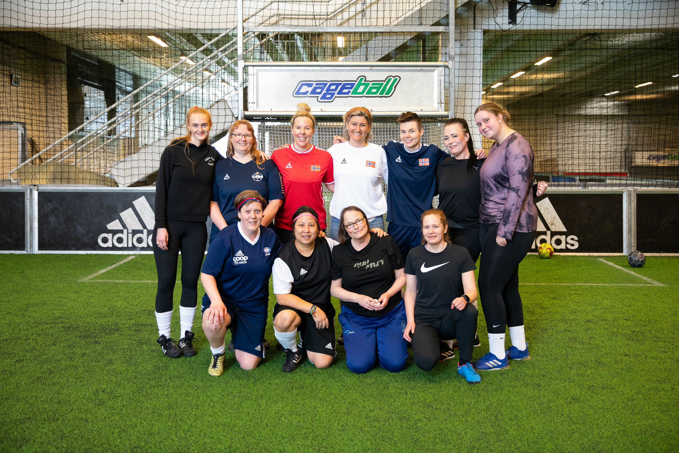 Foto: Lagbilde av fotballdamene. De er ti stykker og i midten på bakerste rekke står landslagssjefen i hvit T-skjorte.