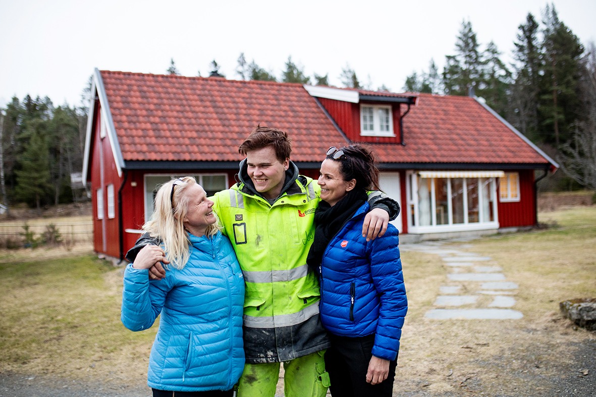 Daniel står mellom miljøterapeut Ine Hansen (t.v) og enhetsleder Lisbethj Sjemmedal (t.h). De holder rundt hverandre og smiler.
