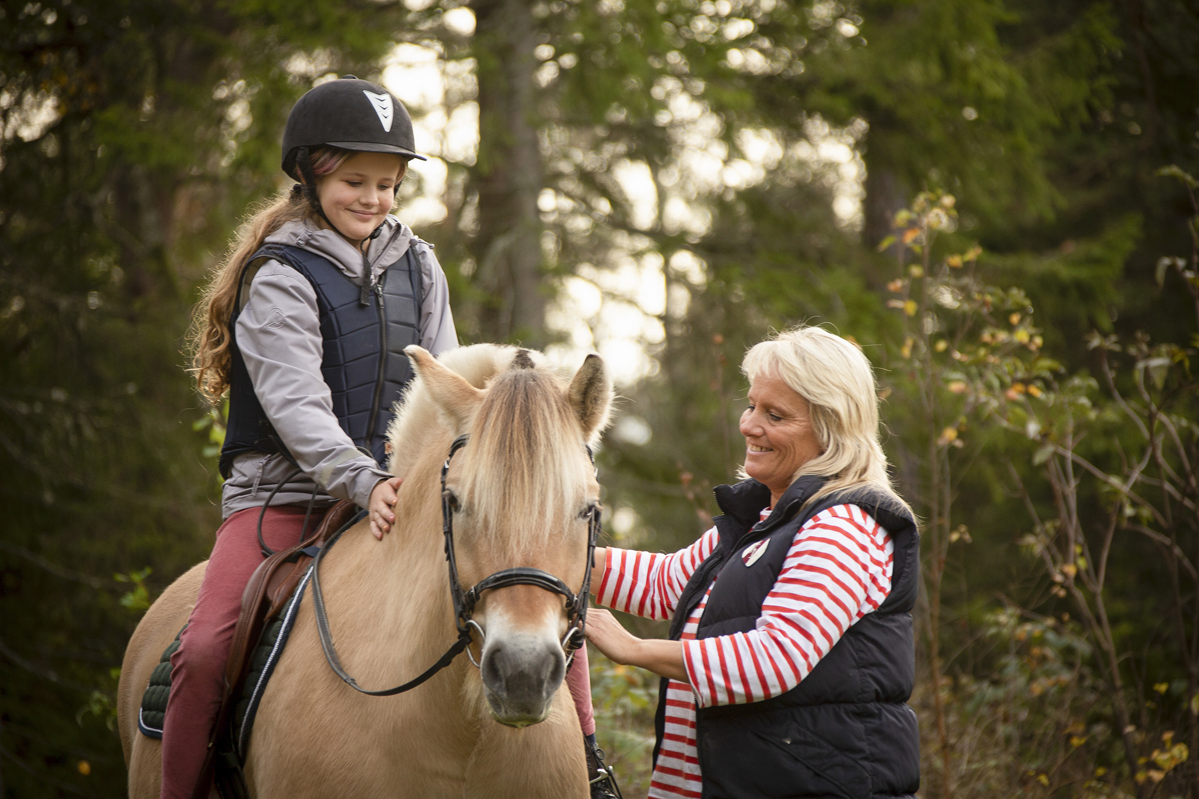Soldammen har to hester. her sitter en jente på hesten mens en av de ansatte holder hesten.