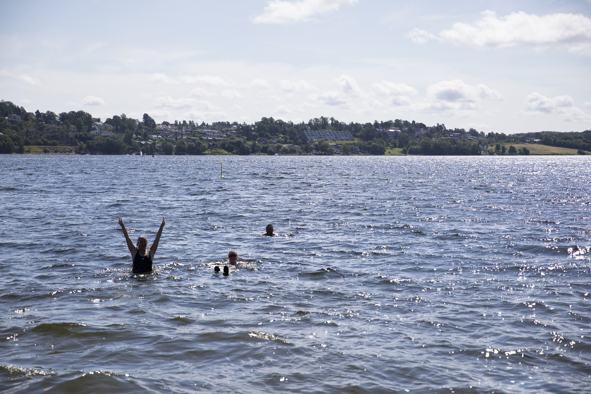 Foto: Fire personer bader i sjøen.