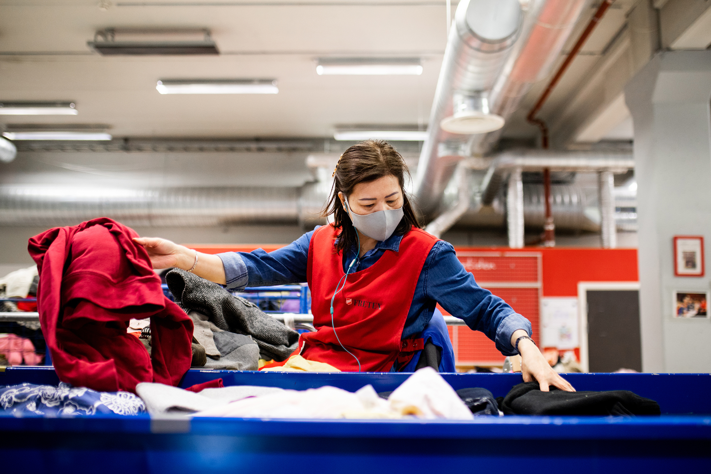 En bruker får klær fra klesutdeling på Fyrlyset og klærne kommer fra Fretex sitt sorteringsanlegg
