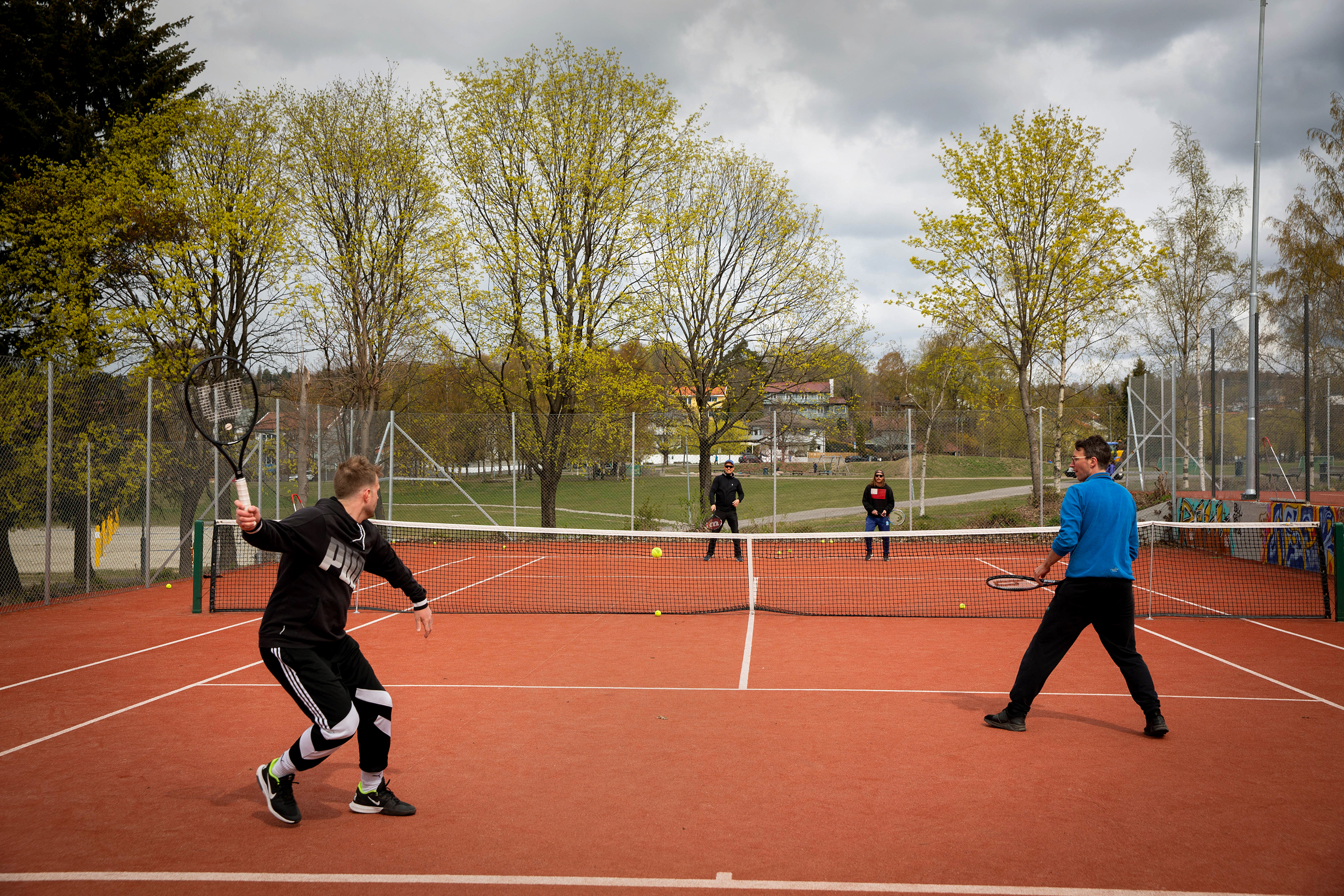 Fire menn spiller tennis (bilde t.v) To hender holder med tatoveringer på fingrene holder i en tennisracet (bilde t. h.)