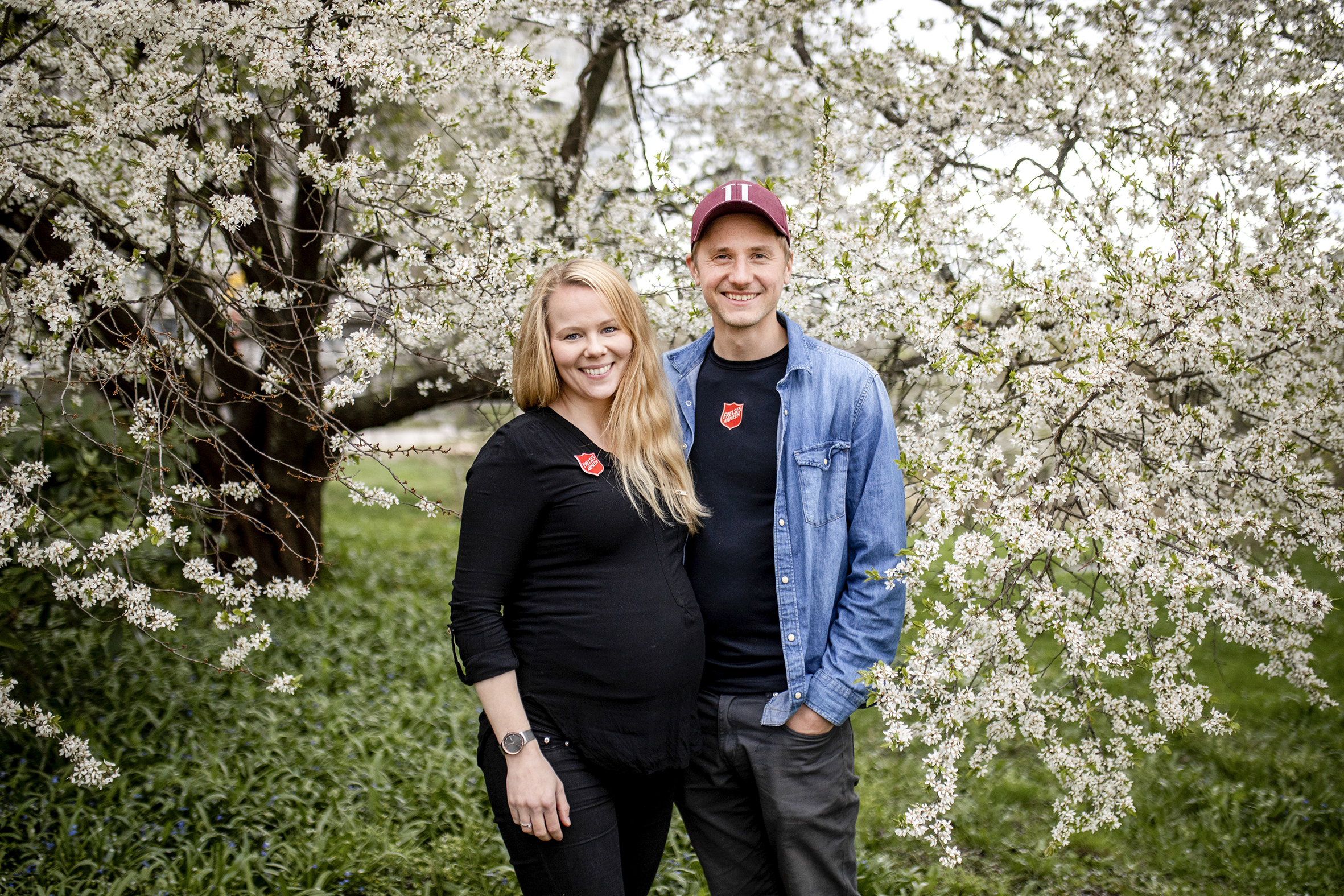 Thea og Andreas Welander står under et blomstrende epletre. De smiler til kameraet.