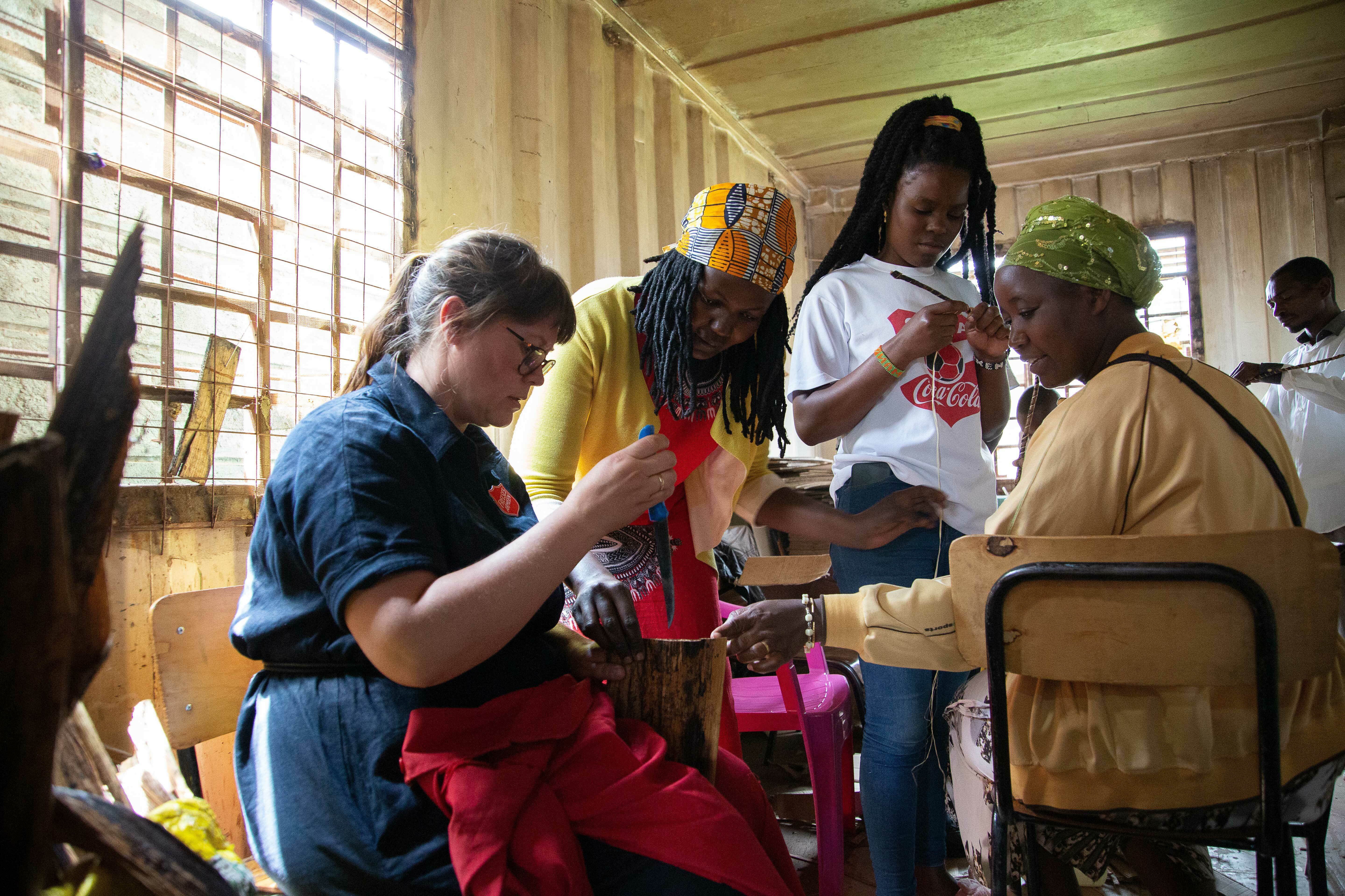 Norsk kvinne sitter ved et bord sammen med tre afrikanske kvinner.