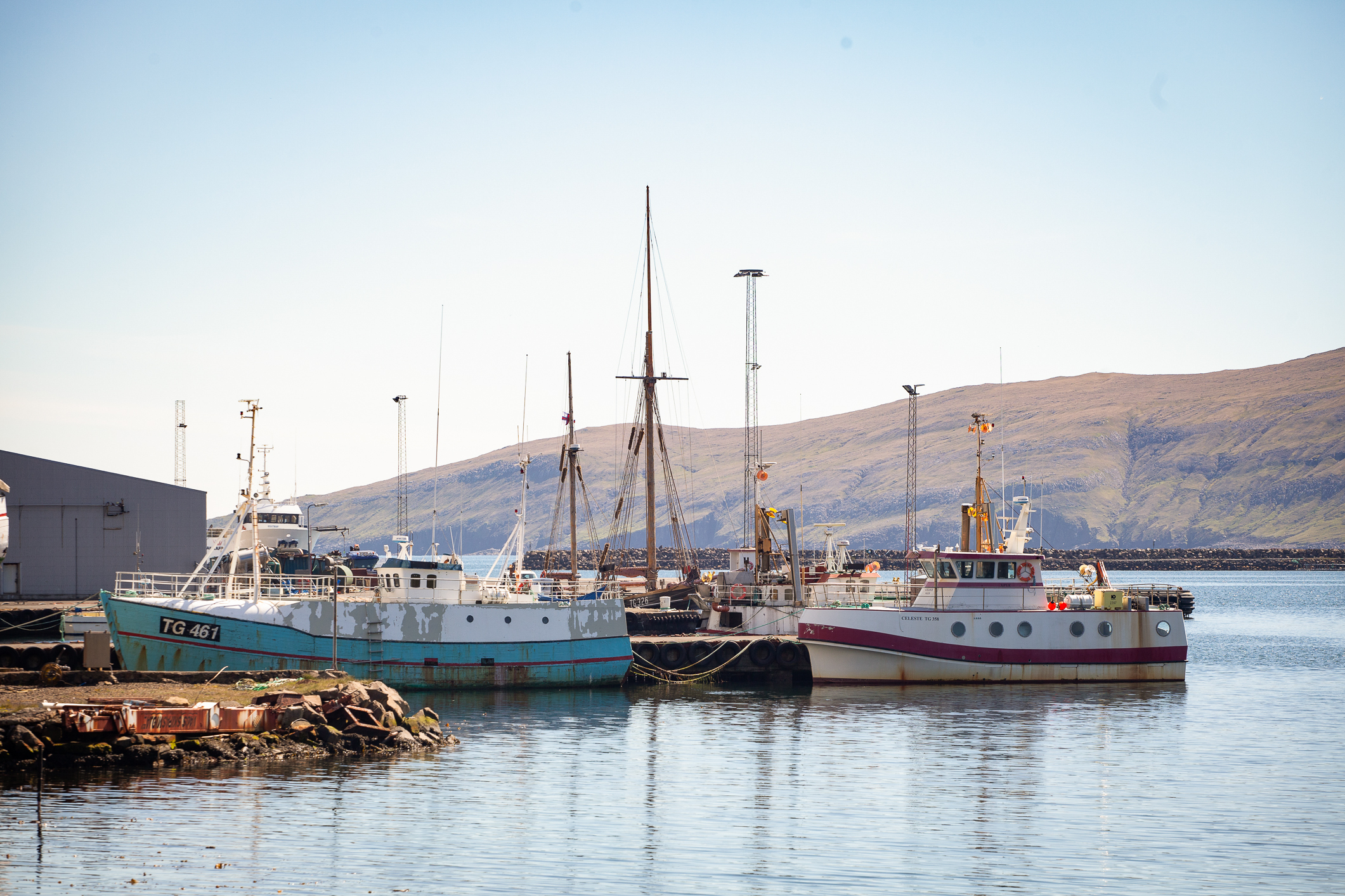 En klynge med mindre fiskebåter ligger til kai.