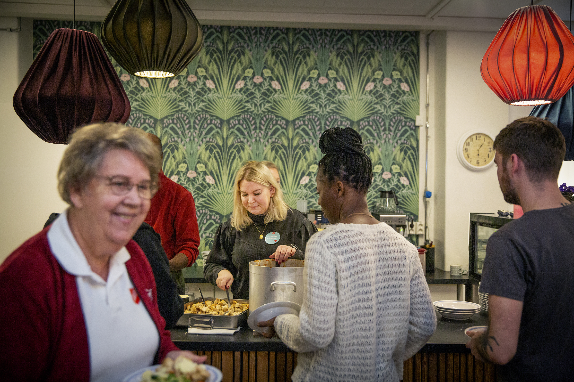 Det første bildet viser Tone Berg som står bak disken i kafeen på Sammen. På det andre bildet står hun med ryggen til og dirigerer koret Closer.