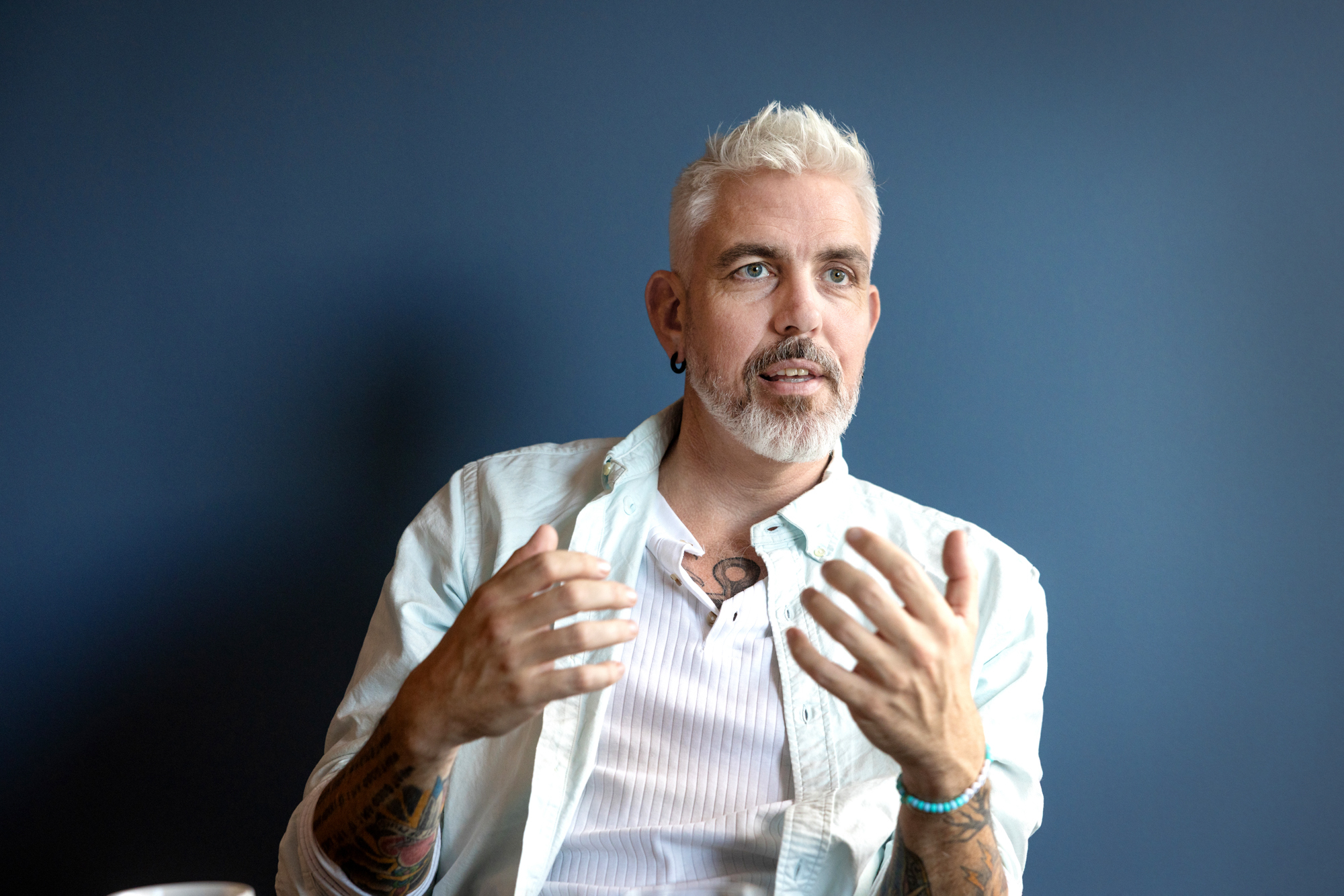Foto: Mann med grått hår og skjegg gestikulerer med hendene.