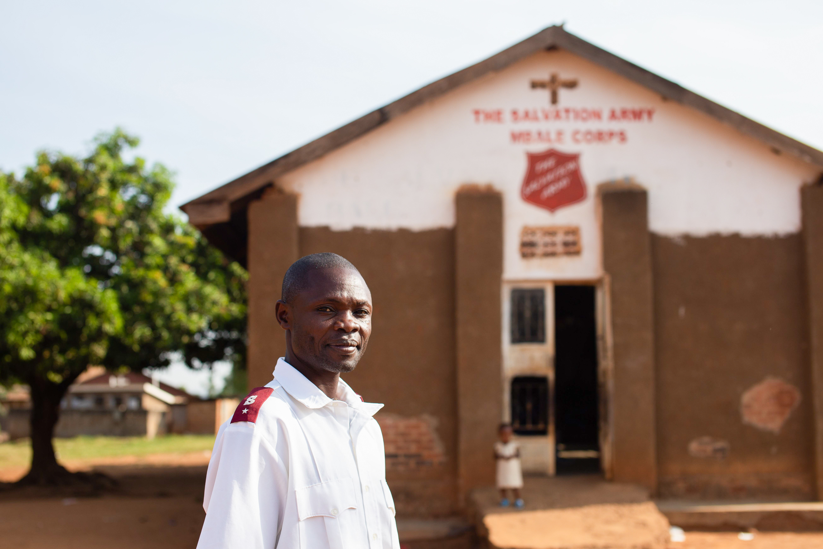 Frelsesarmee kirke i Uganda med en ansatt i uniform foran porten