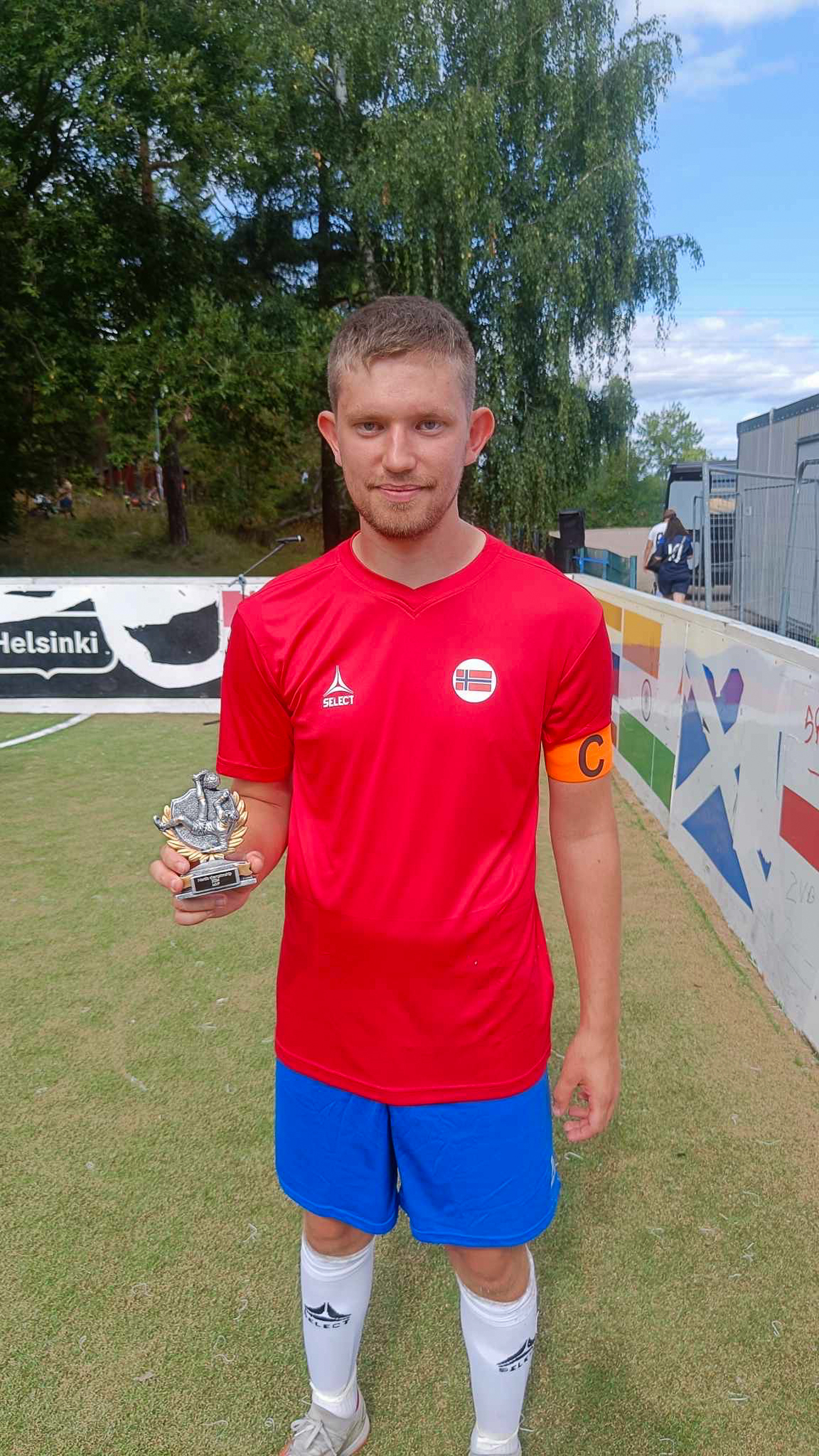 Foto: Mann i landslagsdrakt holder stolt fram en pokal.