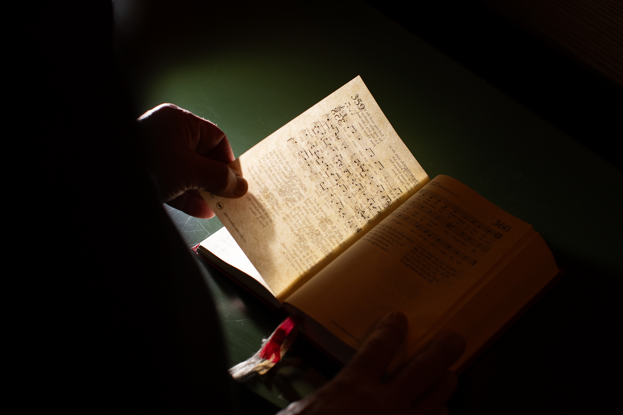 Hånd som blar i en salmebok.