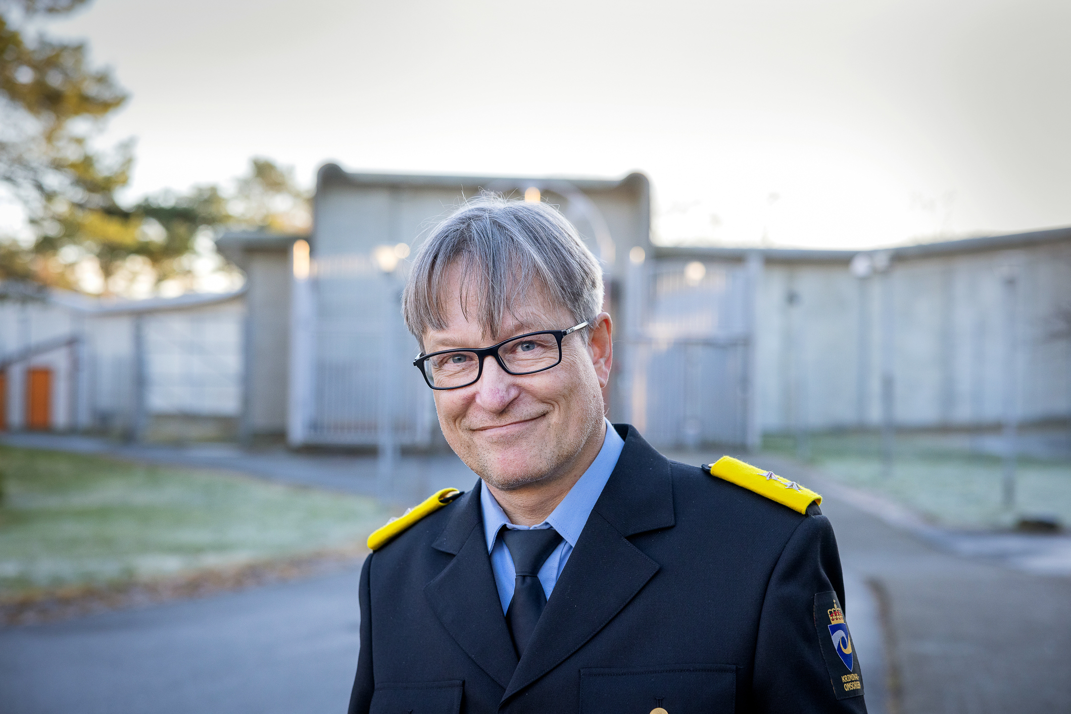 Mann i blå uniform foran fengelset