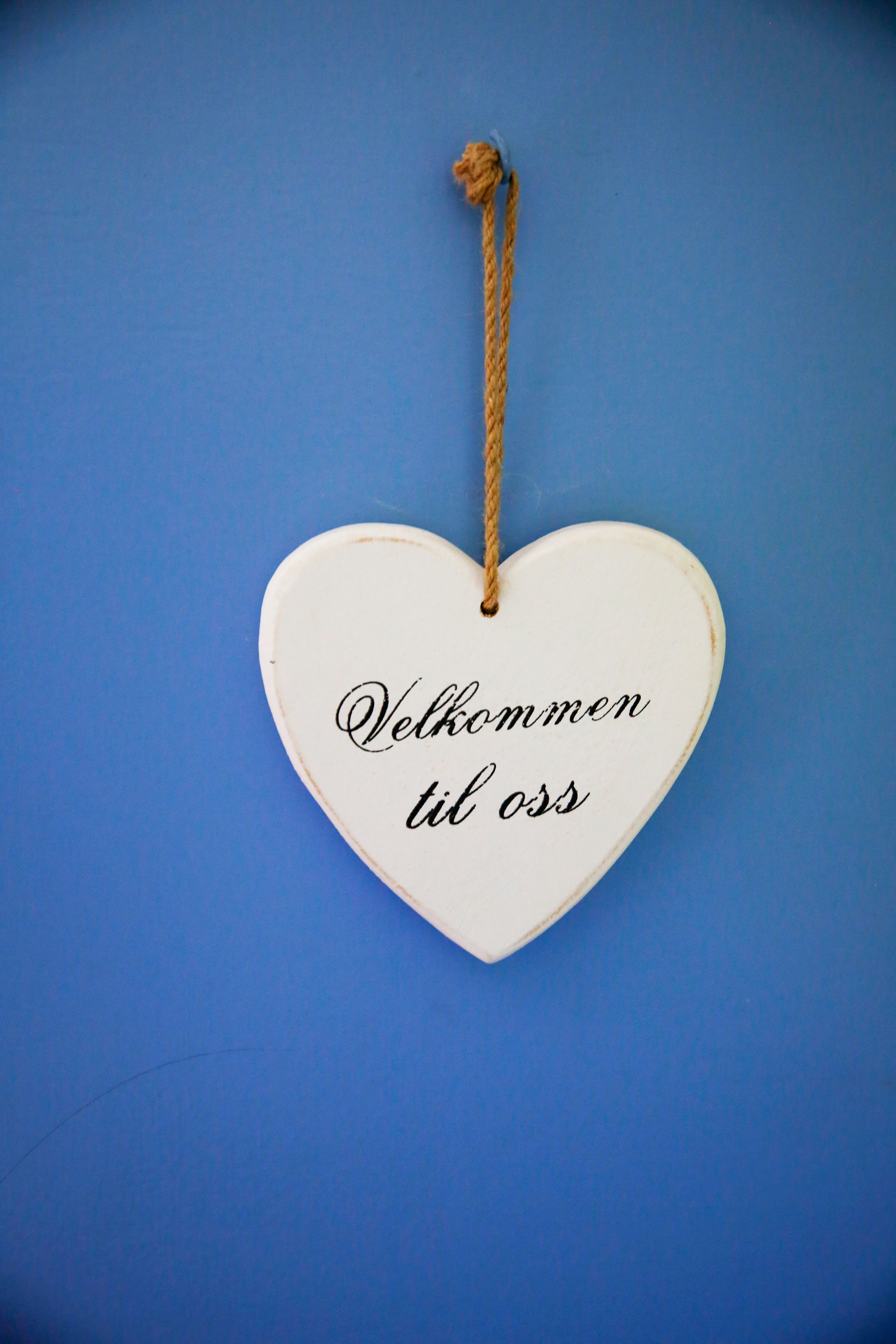 Det første bildet viser Bente og Torfinn som står i døra og smiler, det andre bildet viser et hjerte der det står velkommen til oss.