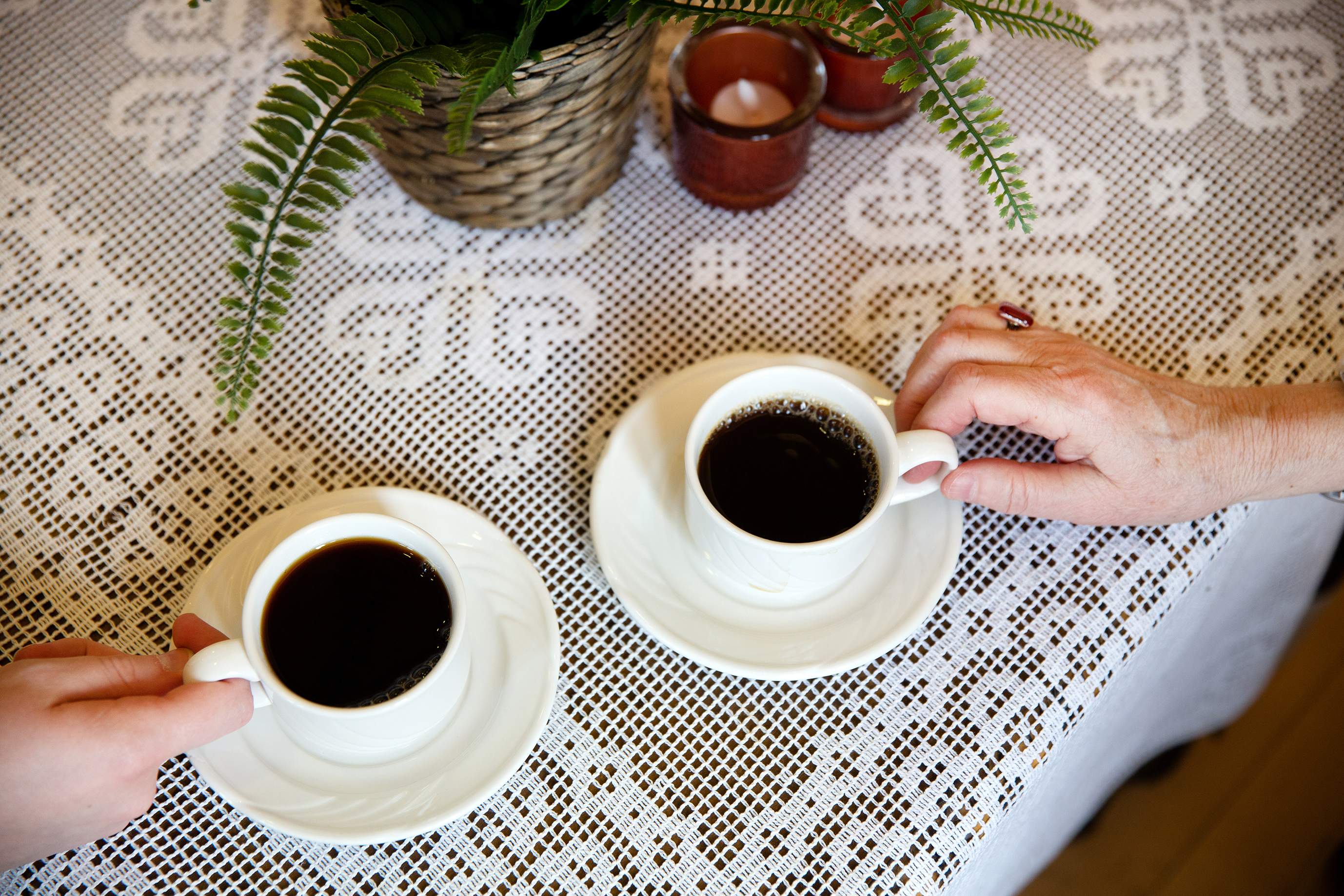 To fulle kaffekopper på en blondeduk i en av stuene på Ensjøtunet. Mange ser fram til å kunne nyte en kopp kaffe i godt selskap