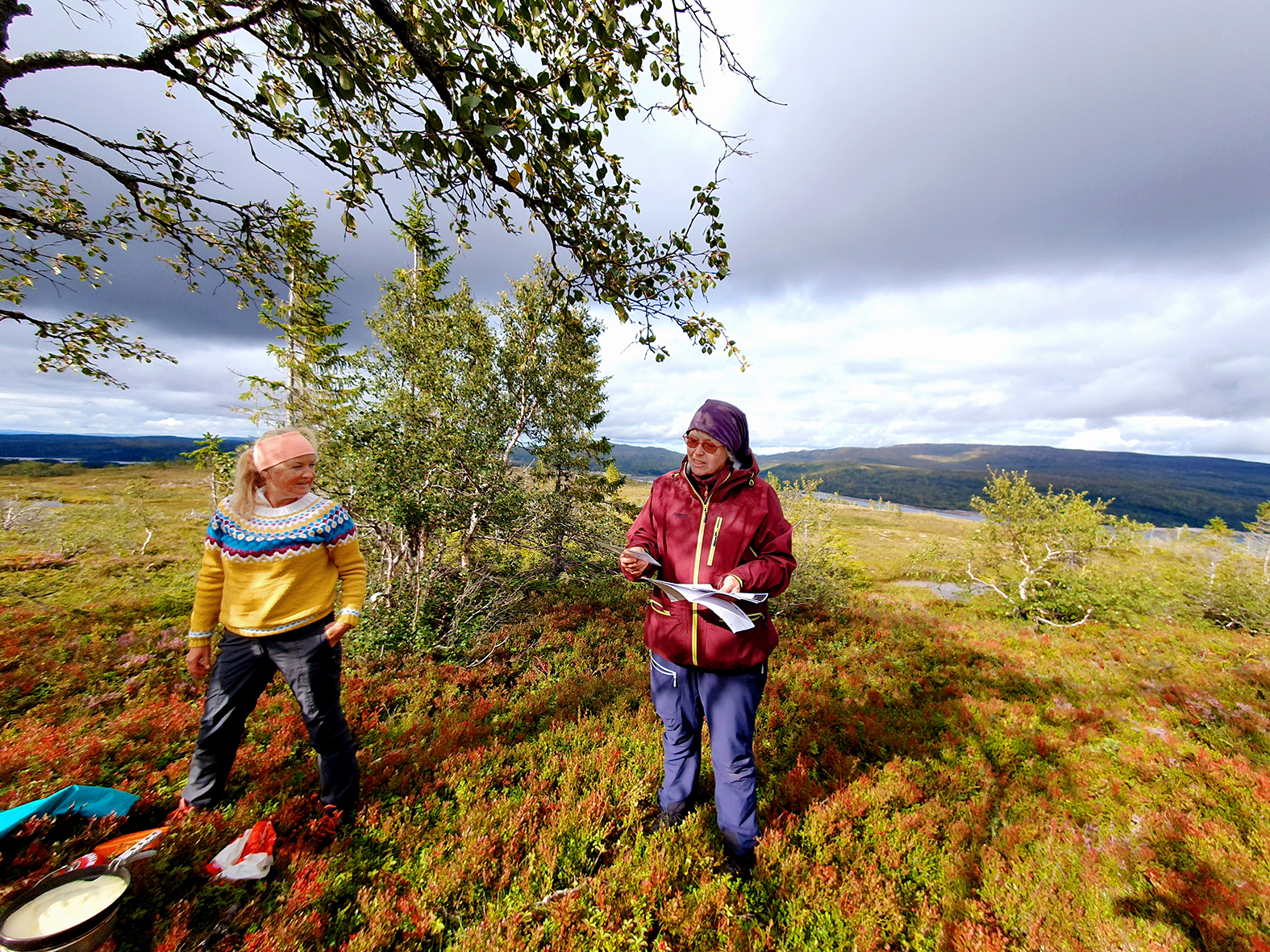 Fengselsbetjent Lise Andersen (t.v.) og Gro Merete Egeland i Frelsesarmeen sørger for påfyll i pausen. Lyng og vidder i gryende høstfarger.