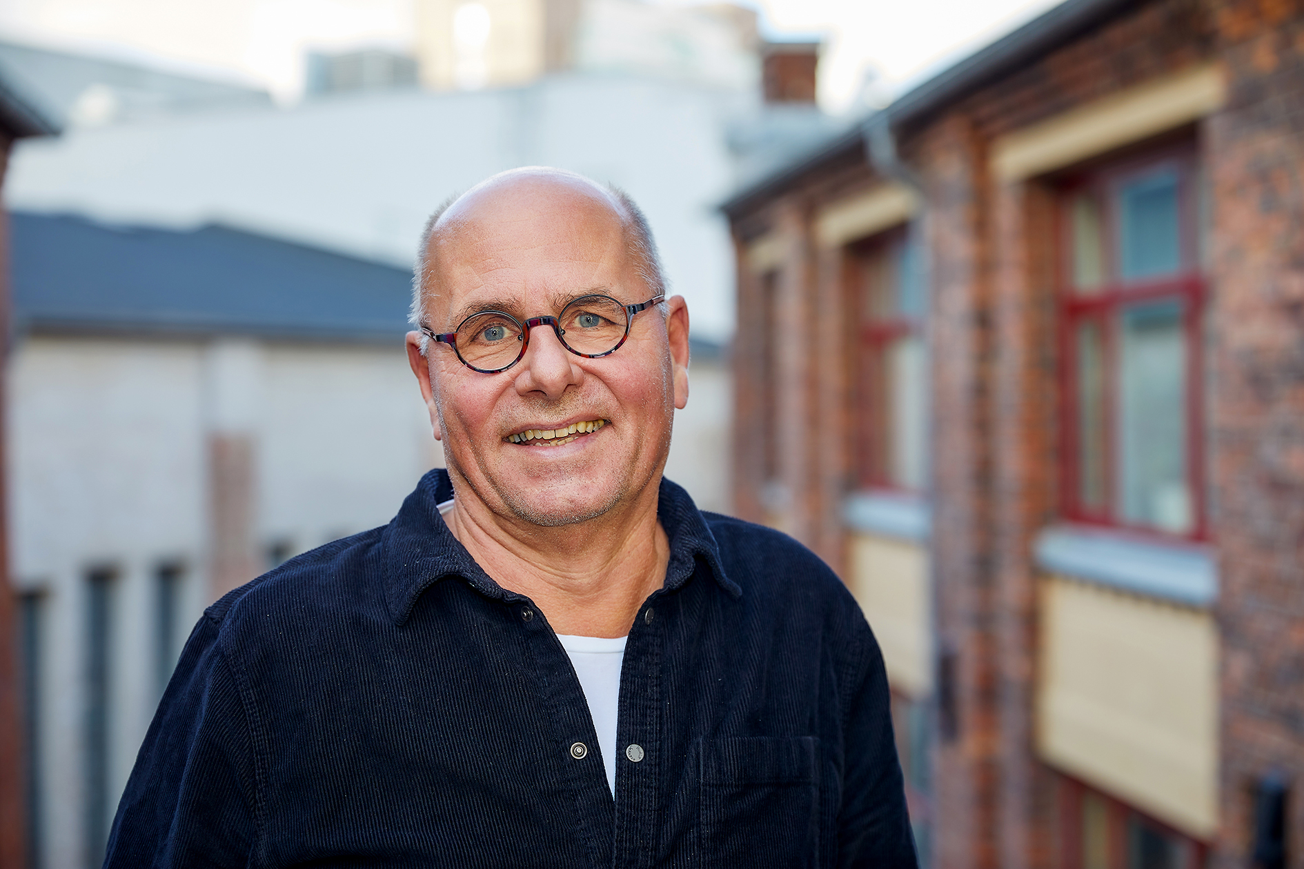 Nærbilde av Svartdahl utendørs, han har på seg svart skjoprte og smiler mot kamera.