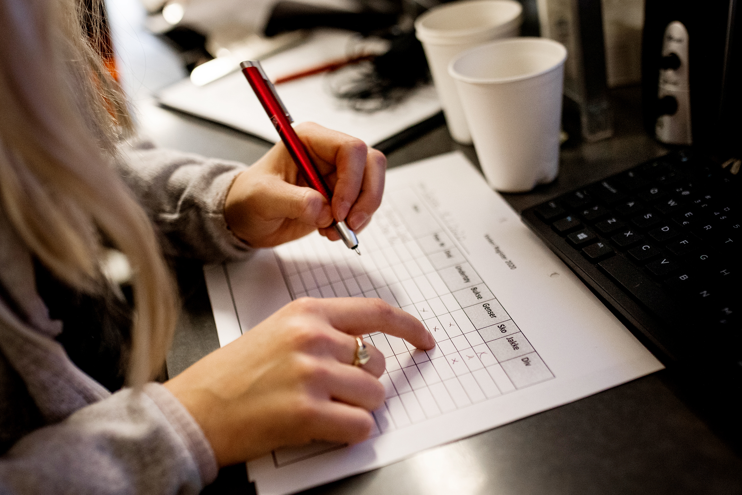 Bilde1: En hånd som holder i en penn og fyller ut et skjema - Bilde2: En haug av sko