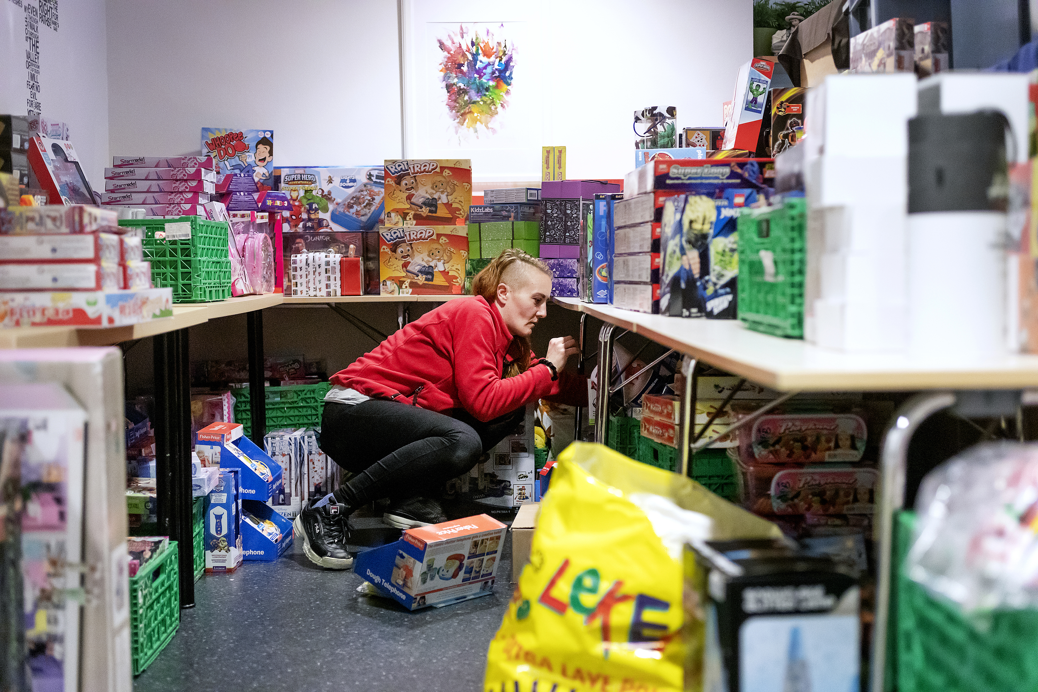 Ann Christin Eitrheim har gjort alt klart til julegaveutdelingen. Hun står inne på et rom fult av leker og gaver til barna.