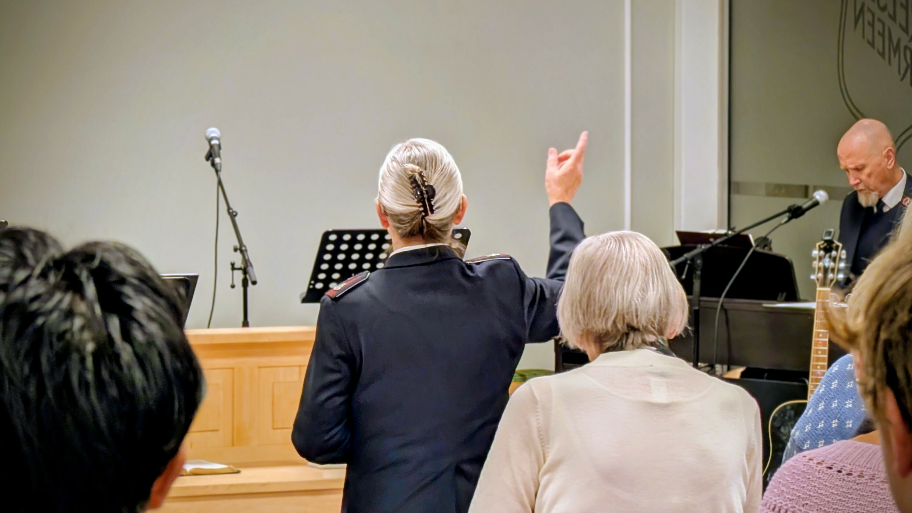 Soldat i Frelsesarmeen løfter hendene i lovsang under Gudstjenesten på Frelsesarmeen i Kragerø