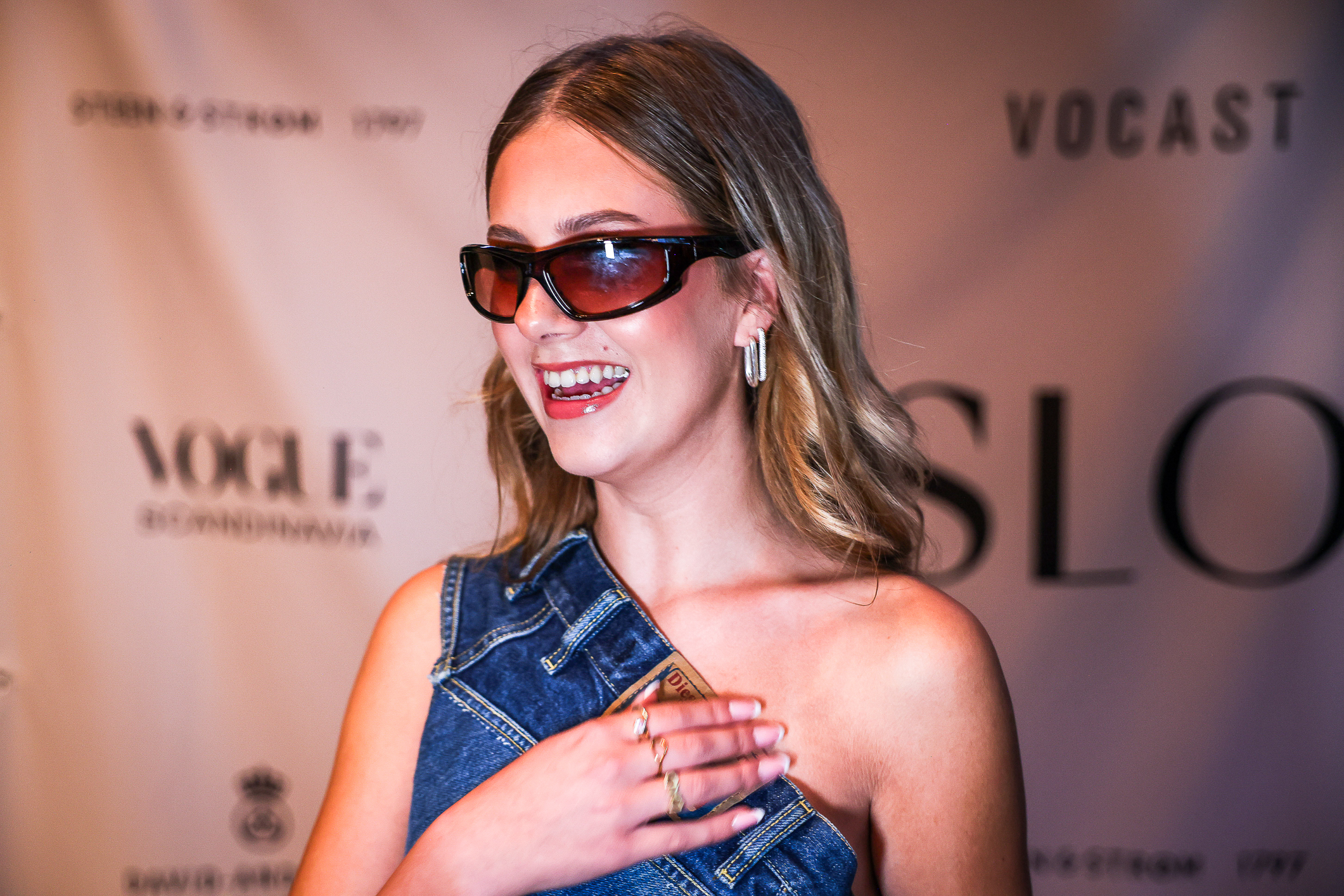 Ung jente med solbriller og en topp sydd av gamle jeans.