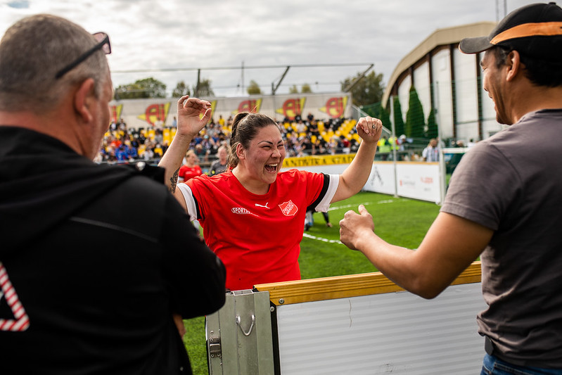 Jublende kvinnelig fotballspiller får medalje