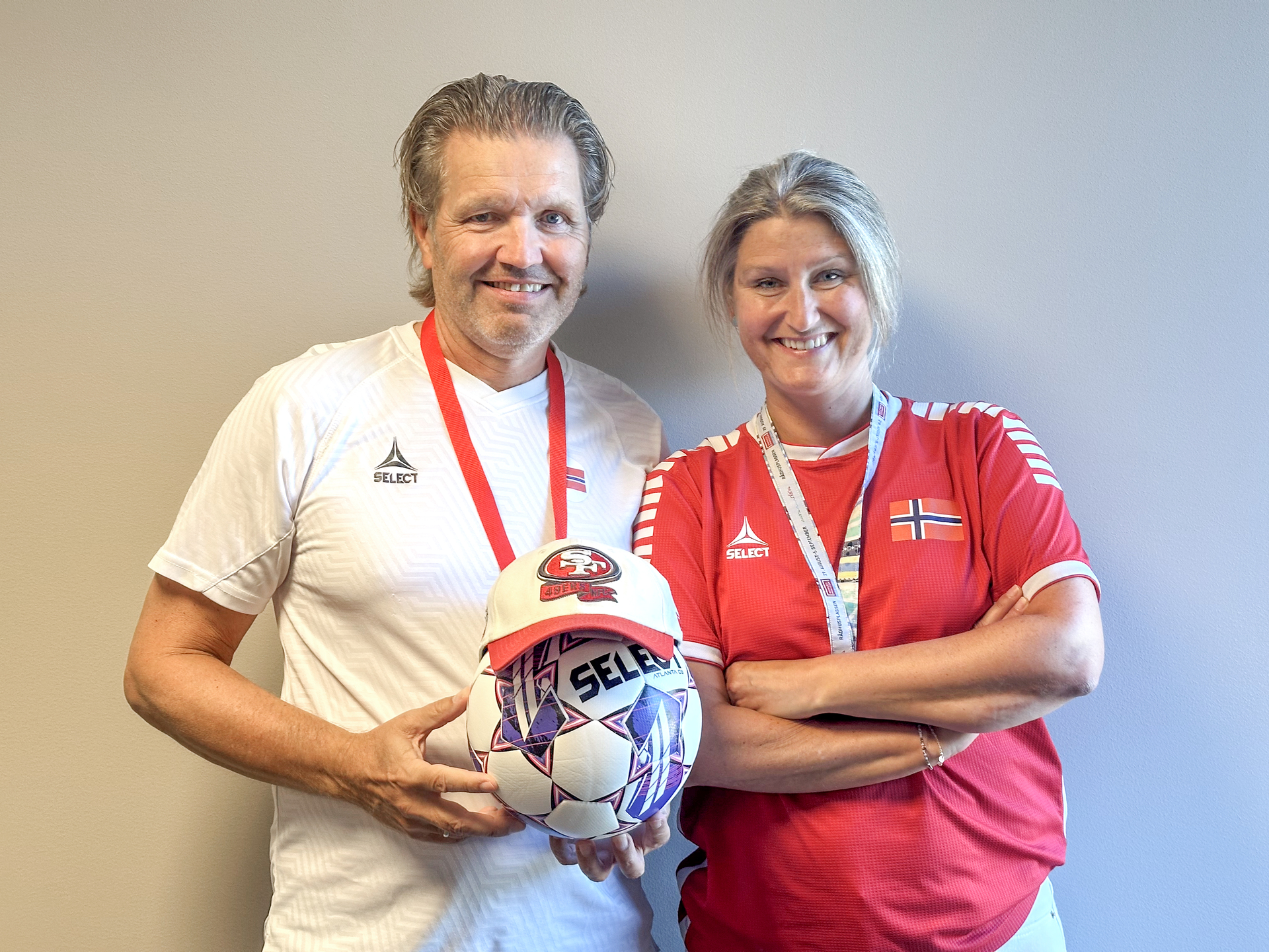 Portrett av Rune og Signe i hvit og rød landslagsdrakt med fotball. Rune Isegran og Signe Haukvik Haugen er sjefene for de norske landslagene for henholdsvis herrer og damer