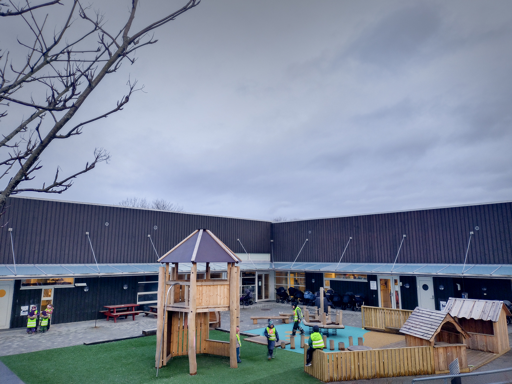 Foto: To bilder etter hverandre der vi ser en lekeplass med turkis og grønt dekke med lekeapparater fra forskjellige vinkler i barnehagen.