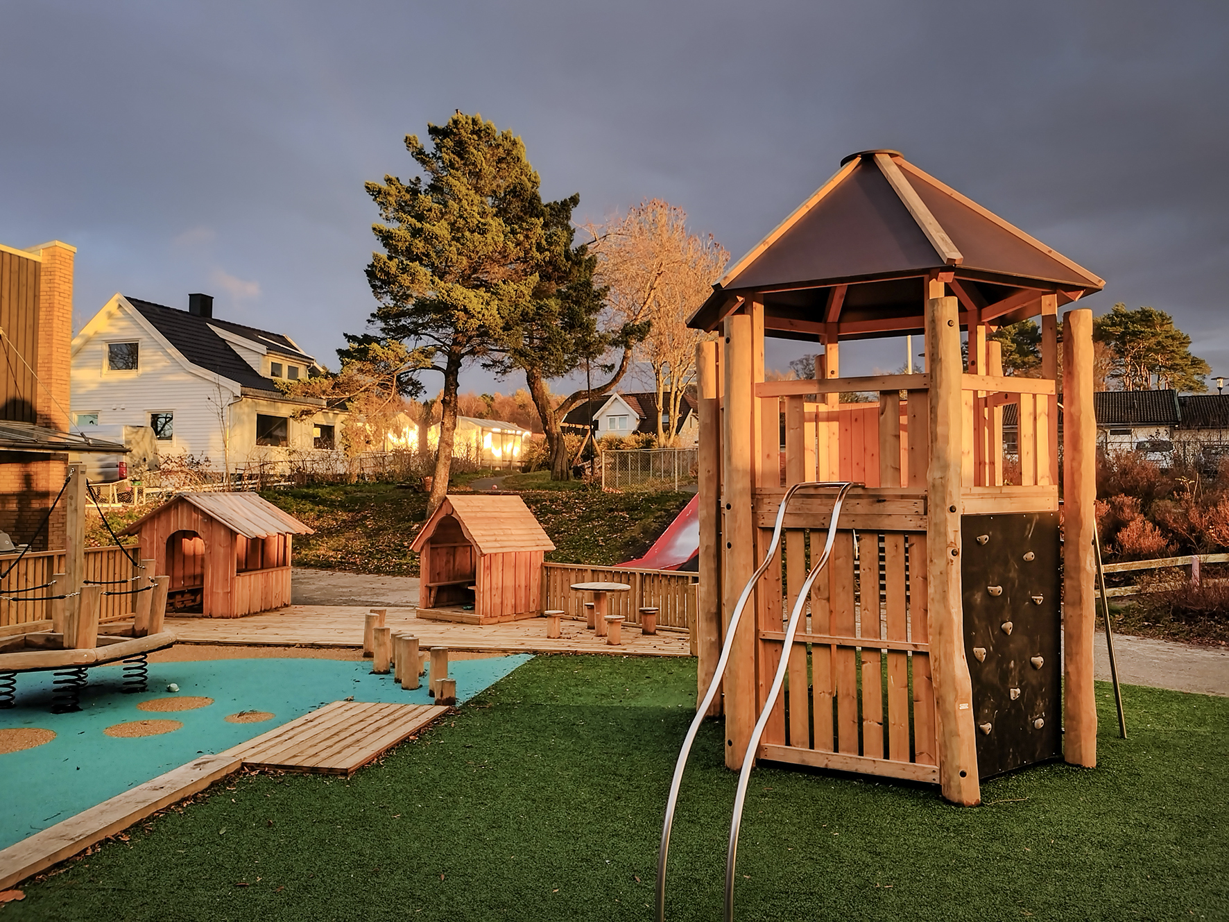 Foto: Lekeplass i en barnehage som bader i vakkert kveldslys.