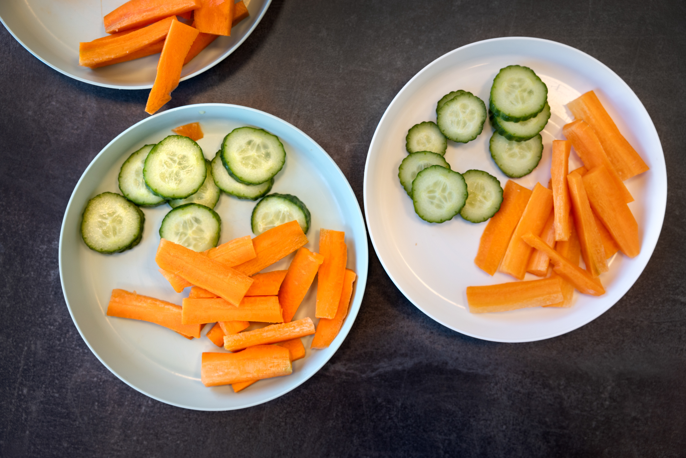 To tallerkener med oppskåret agurk og gulrot.