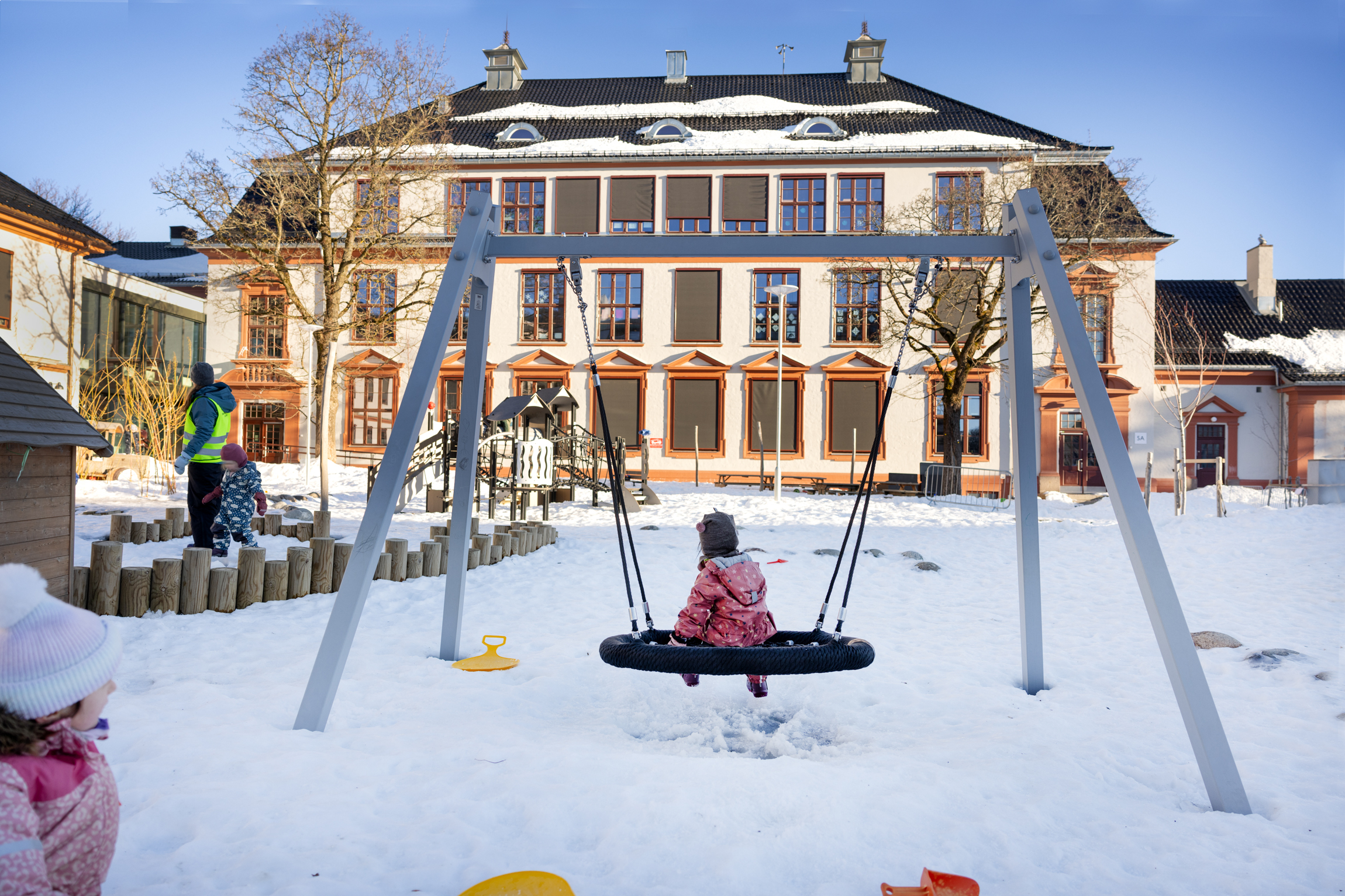 Teisentoppen, Frelsesarmeens barnehage i Oslo. Snø på bakken og huskestativ i forgrunnen.
