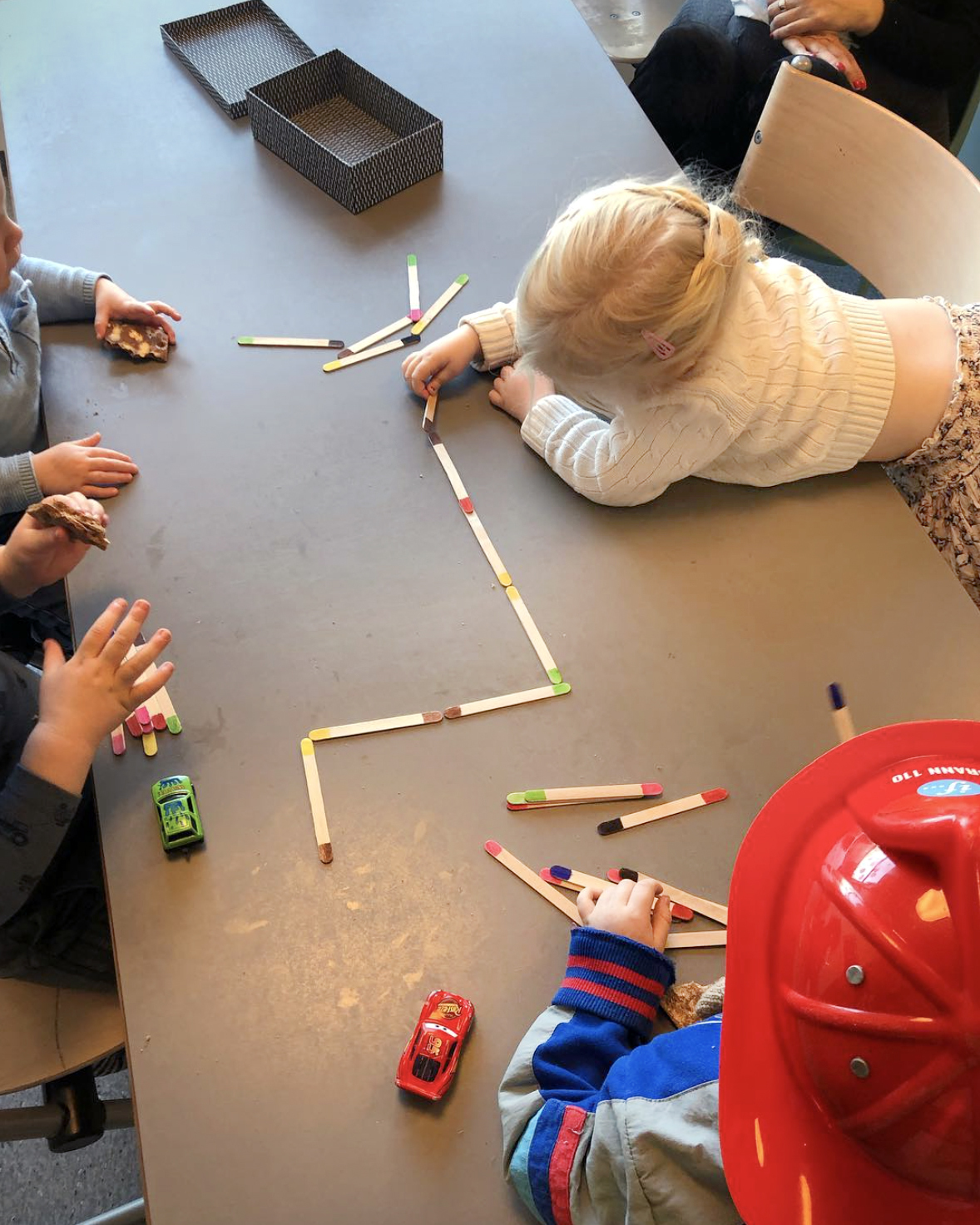 Foto: To bilder etter hverandre. På det første bruker barn epler til å trykke med maling på et stort papir. De lager et tre. På det andre er det barn som leker ved et bord.