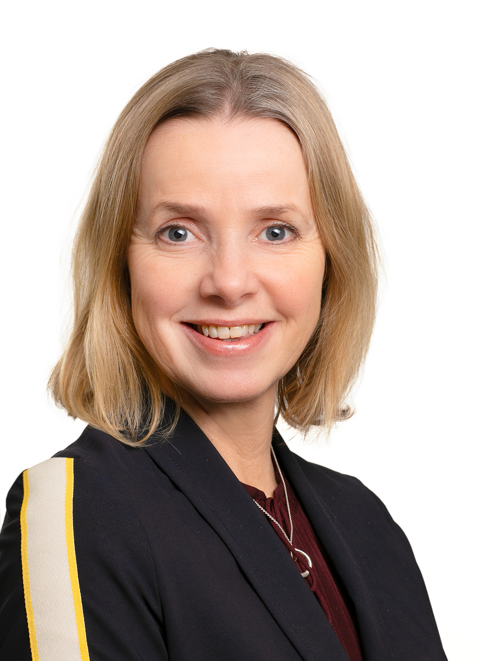 Foto: Nærbilde av kvinne med blond bobfrisyre. Hun smiler mot kamera.