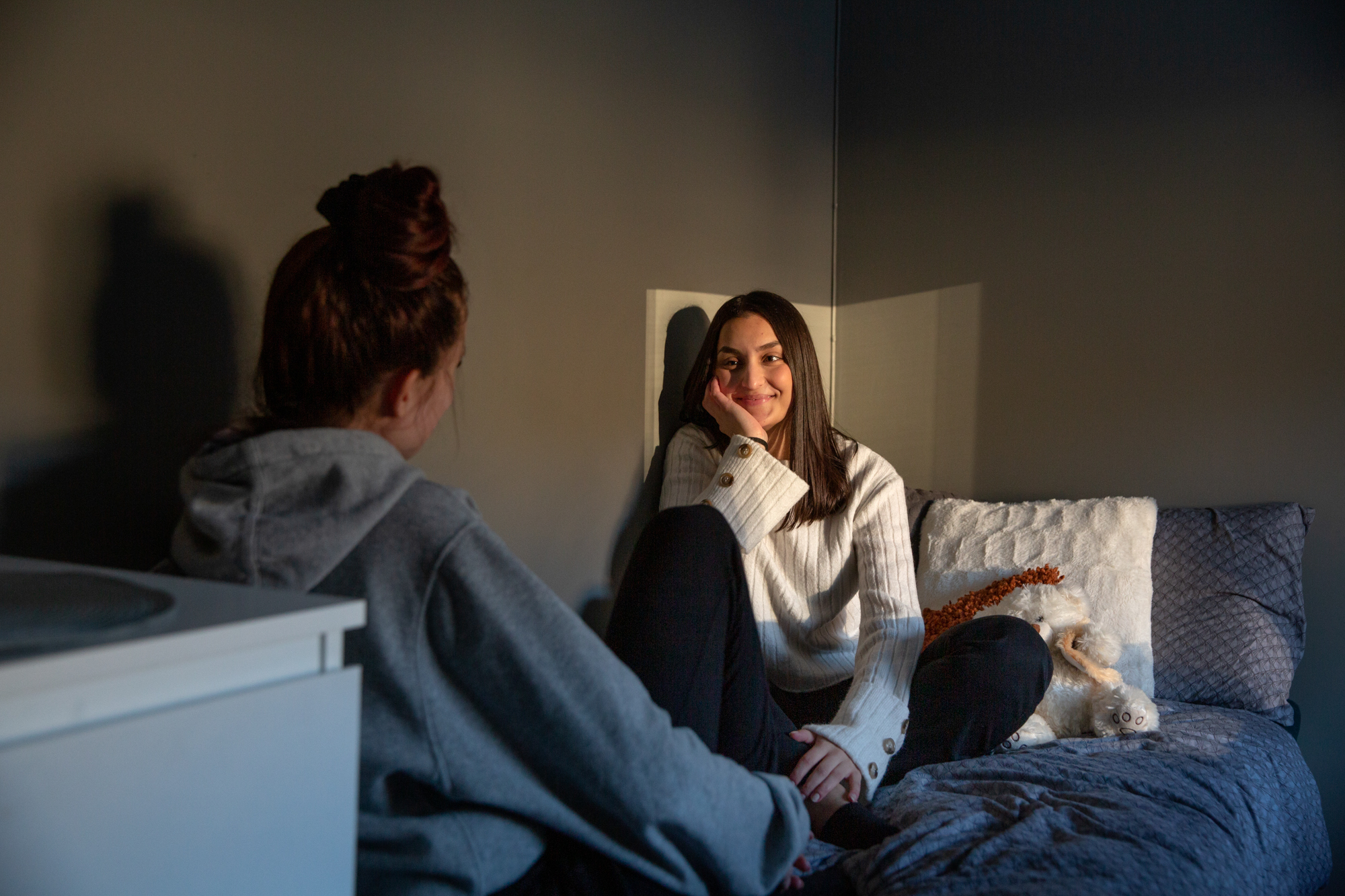 Tenåringsjenter sitter i en seng og snakker