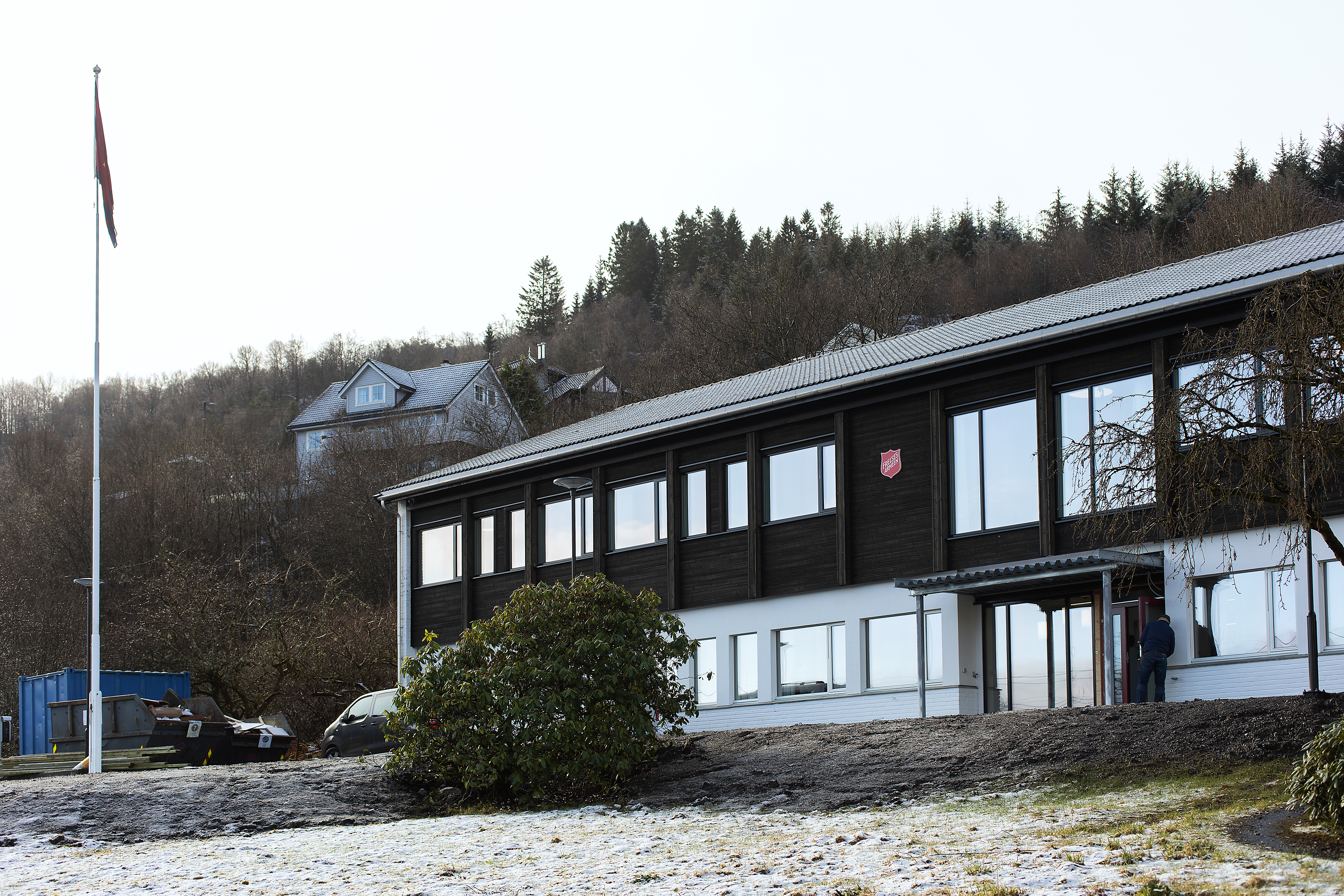Eksteriørbilde av Gatehospitalet i Bergen. En brun og hvis bygning med Frelsesarmeens røde logo på.