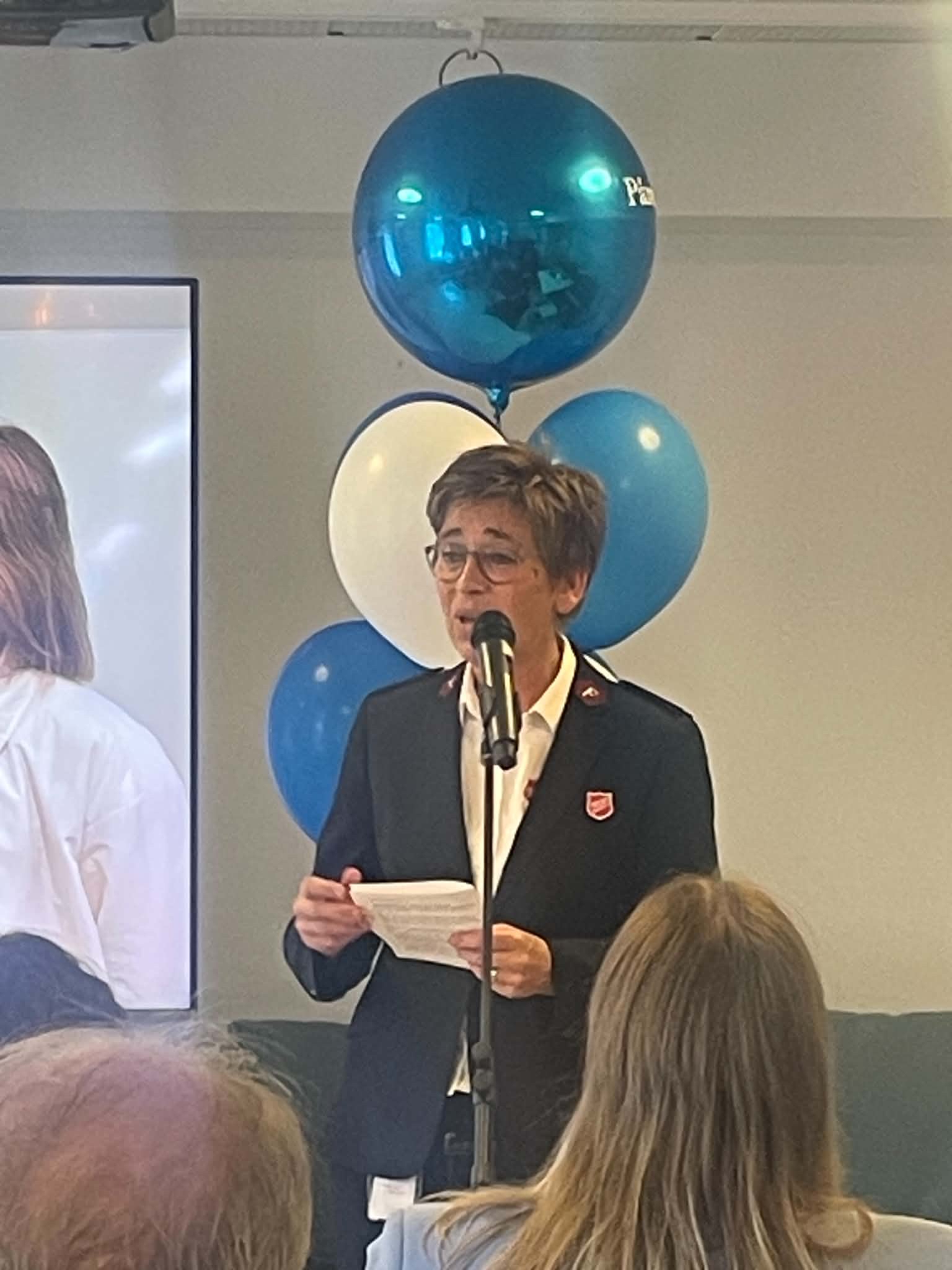 Wenche Walderhaug Midjord holder tale i et ballongpyntet rom