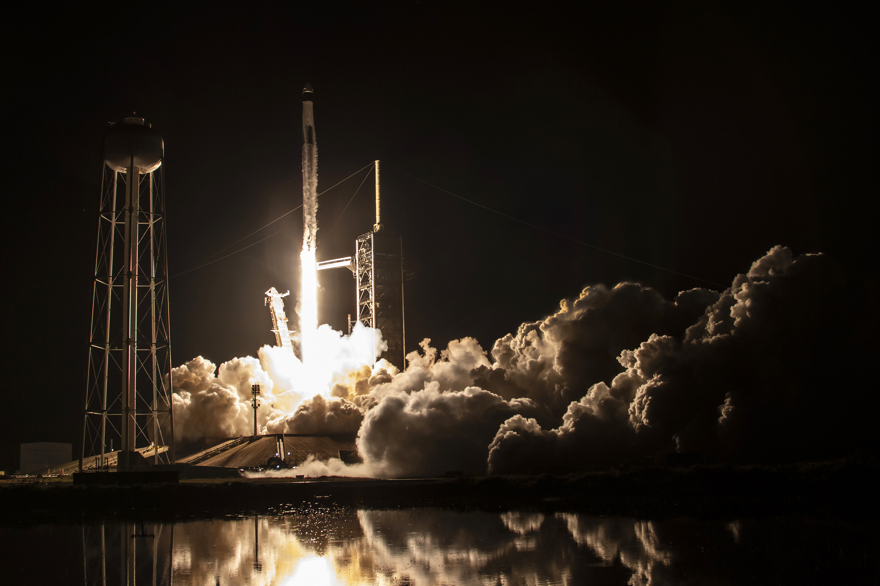 Foto: Raketten skytes opp. Det er mørkt, lyset fra raketten sees med store skyer rundt.