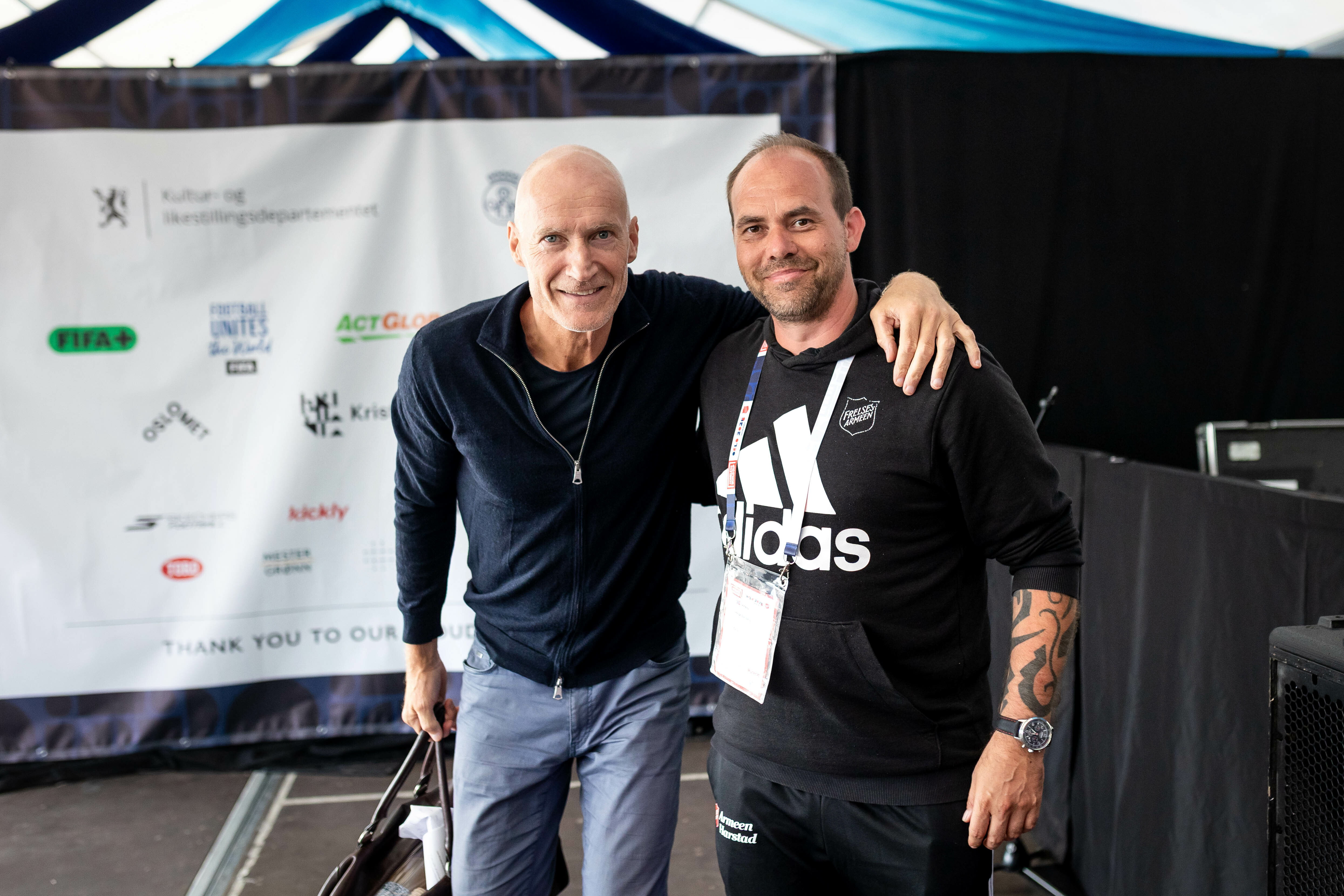 Foto: To menn står og smiler mot kamera. Erik Thorstvedt til venstre holder armen rundt Helge Dahlberg.