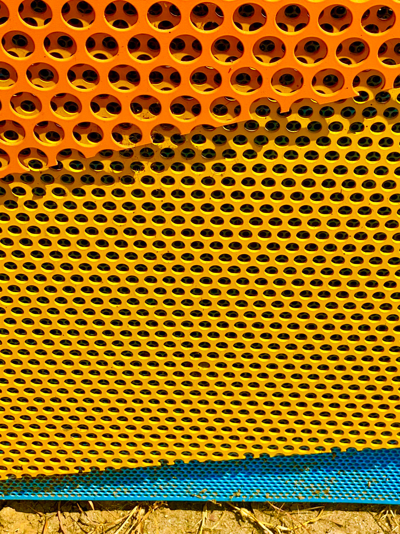 Detail view of the perforated panels layered on top of each other.