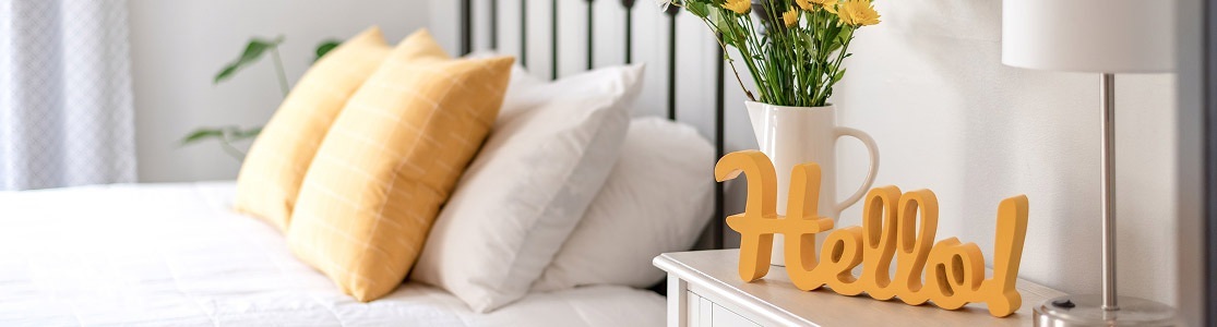 Image of a bright bedroom with a hello sign