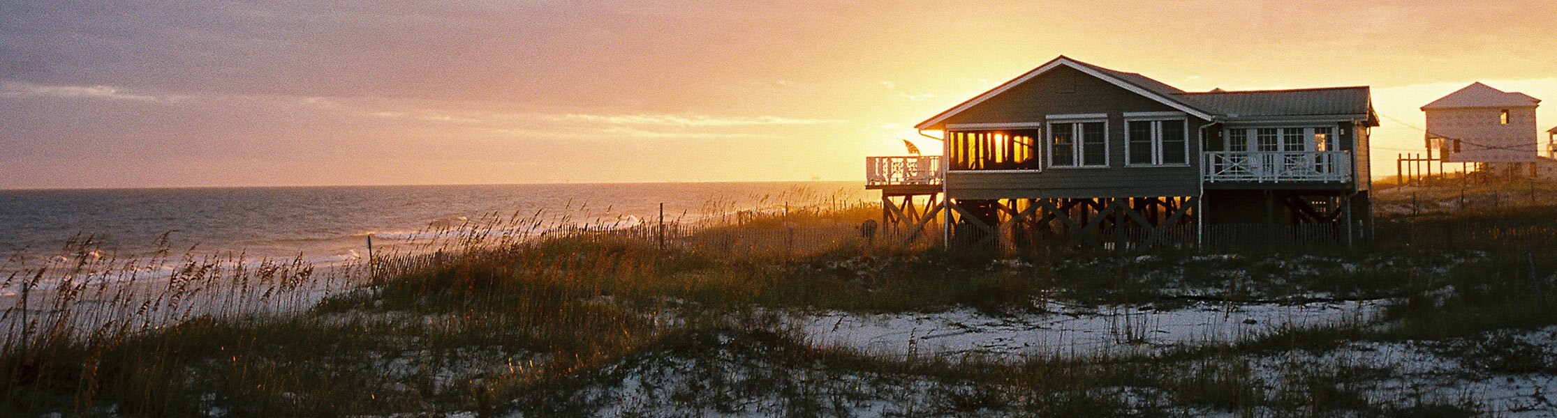 Image of a beach home on the coast during sunset