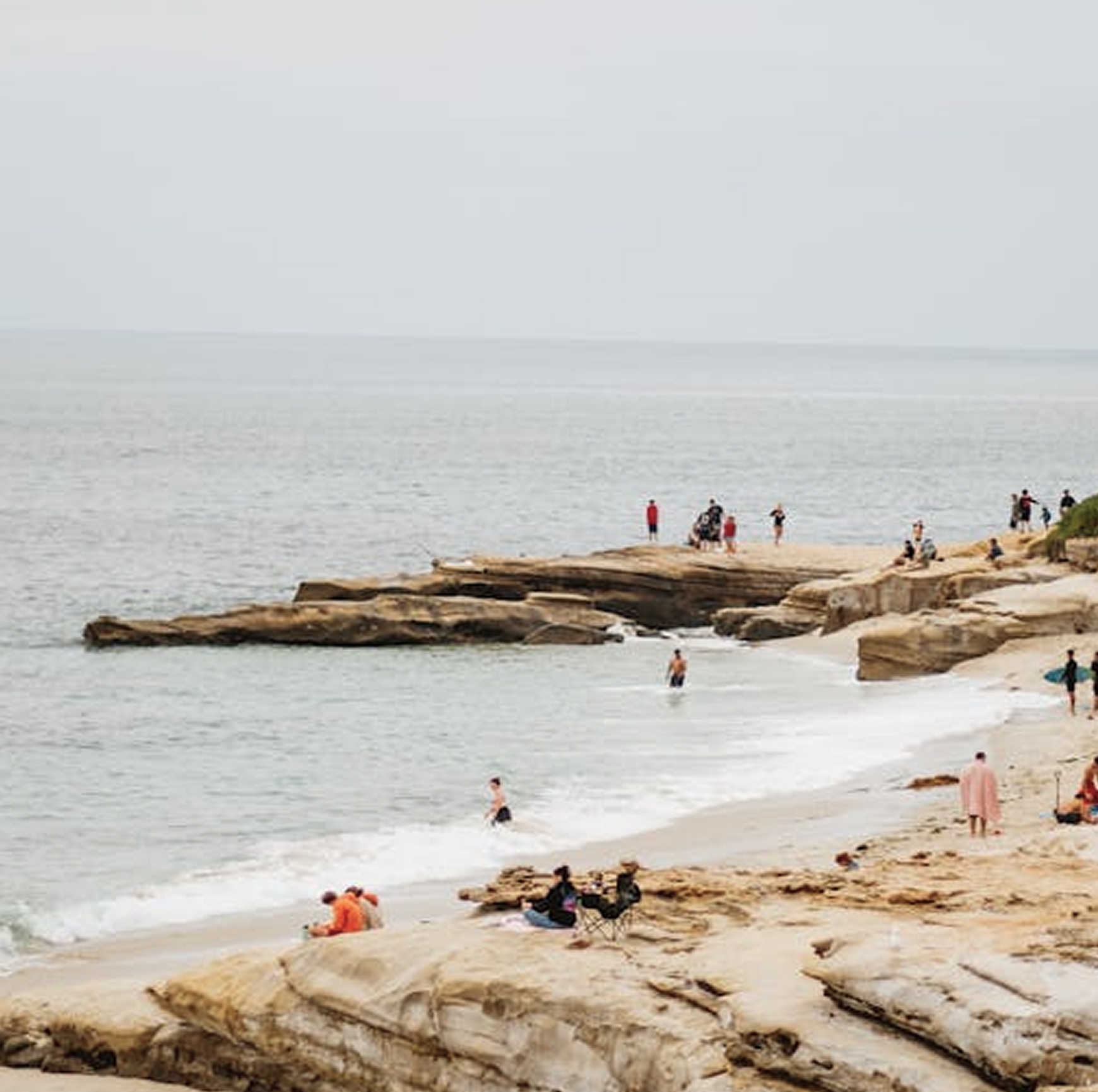 Image of a beach coast with people walking around