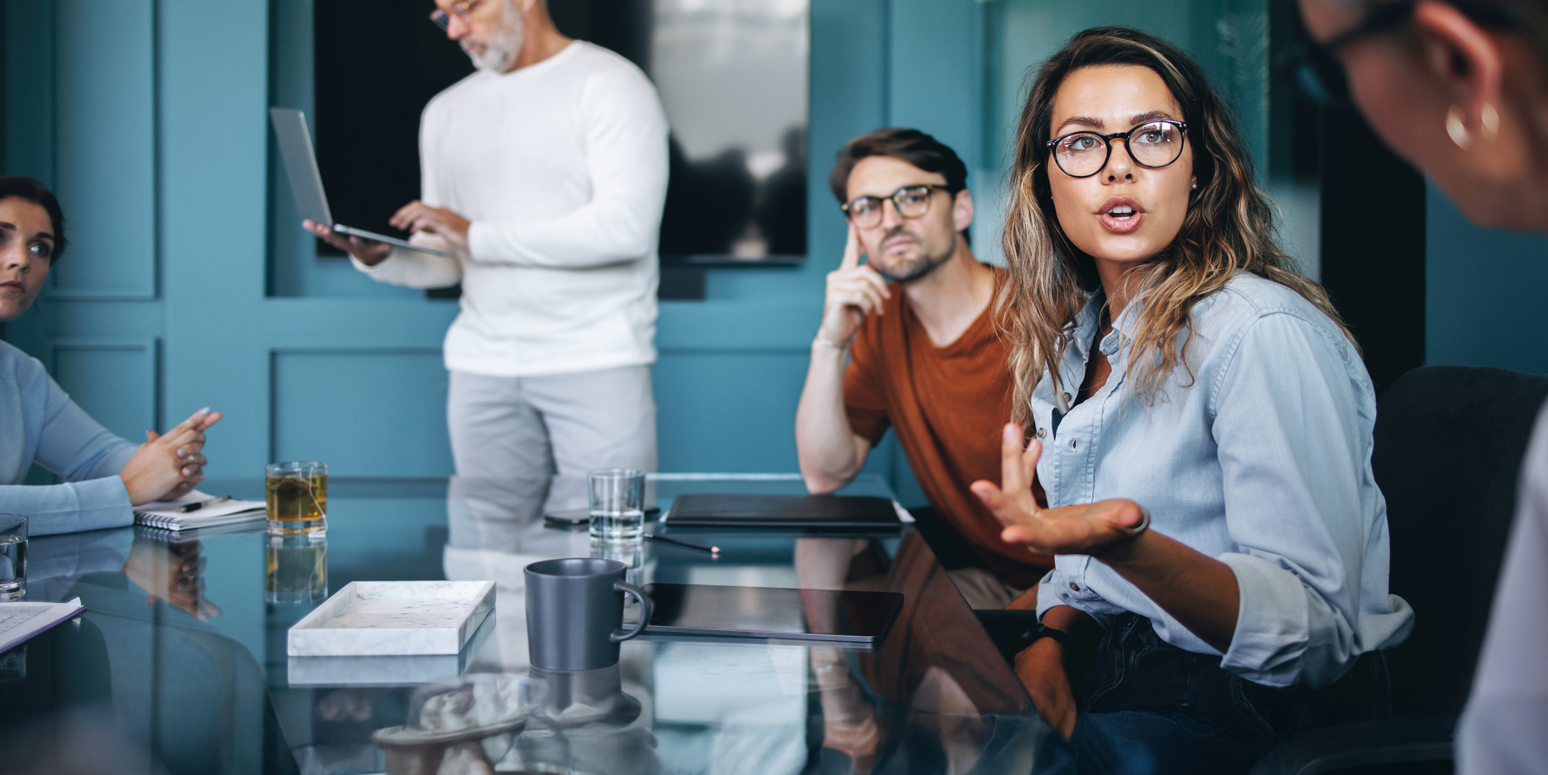 Faites carrières chez COFOMO en transformation numérique et intelligence artificielle - Femme discutant avec des clients autour d'une table.