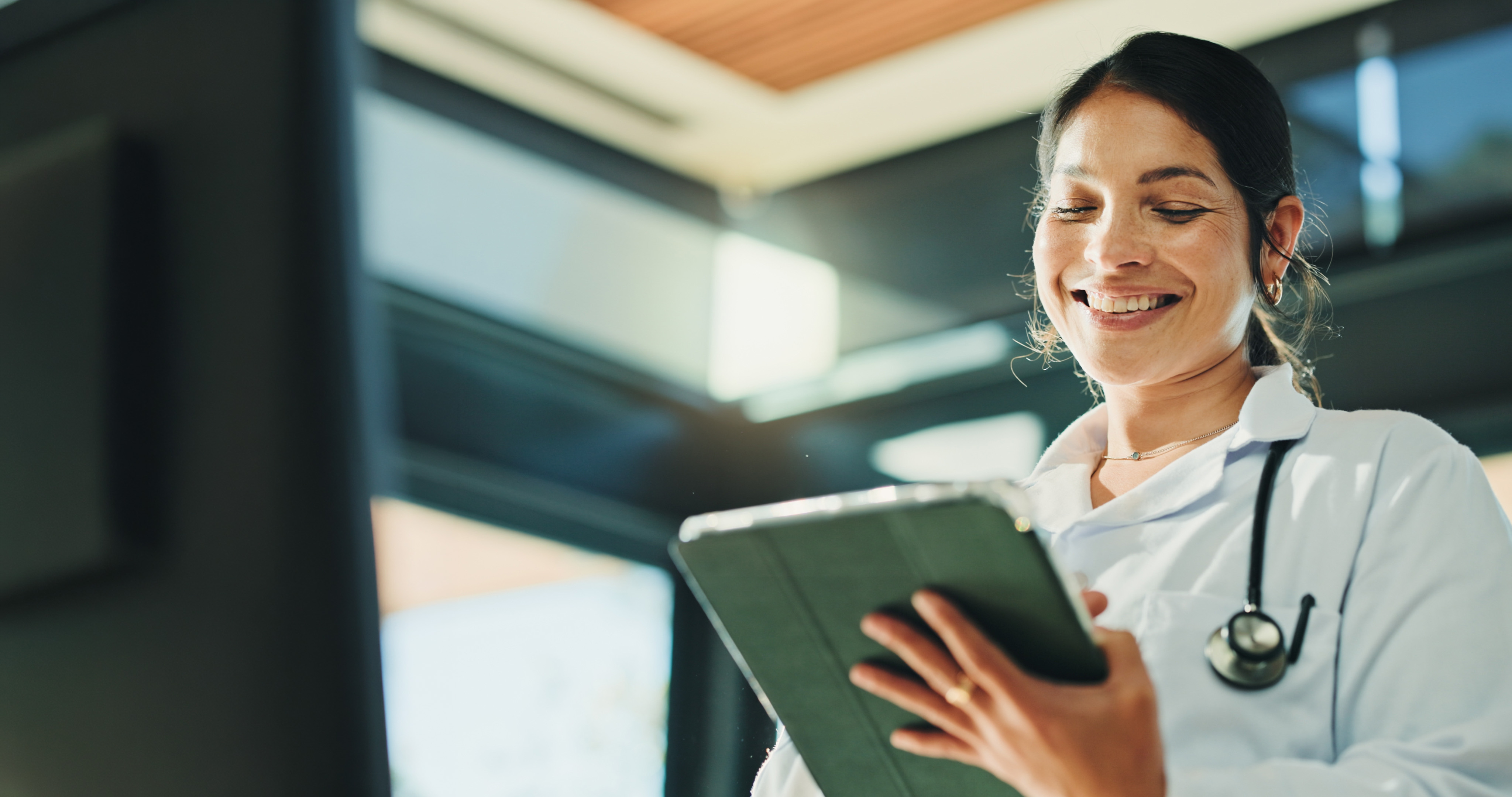 COFOMO – Specialized firm in digital transformation and artificial intelligence for the healthcare industry – Young woman using an iPad to track her team’s performance.